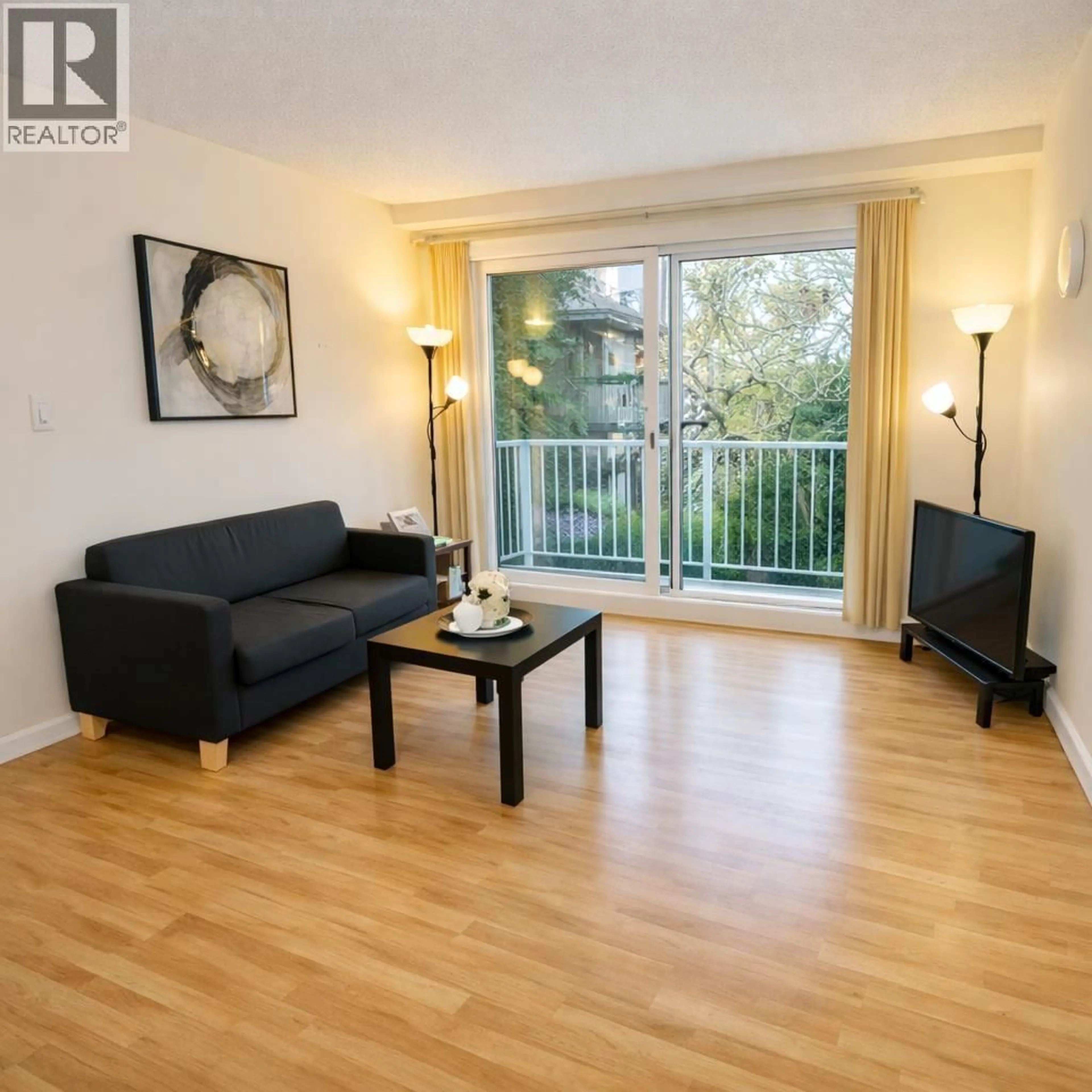 Living room with furniture, wood/laminate floor for 203 - 7200 LINDSAY ROAD, Richmond British Columbia V7C3M6