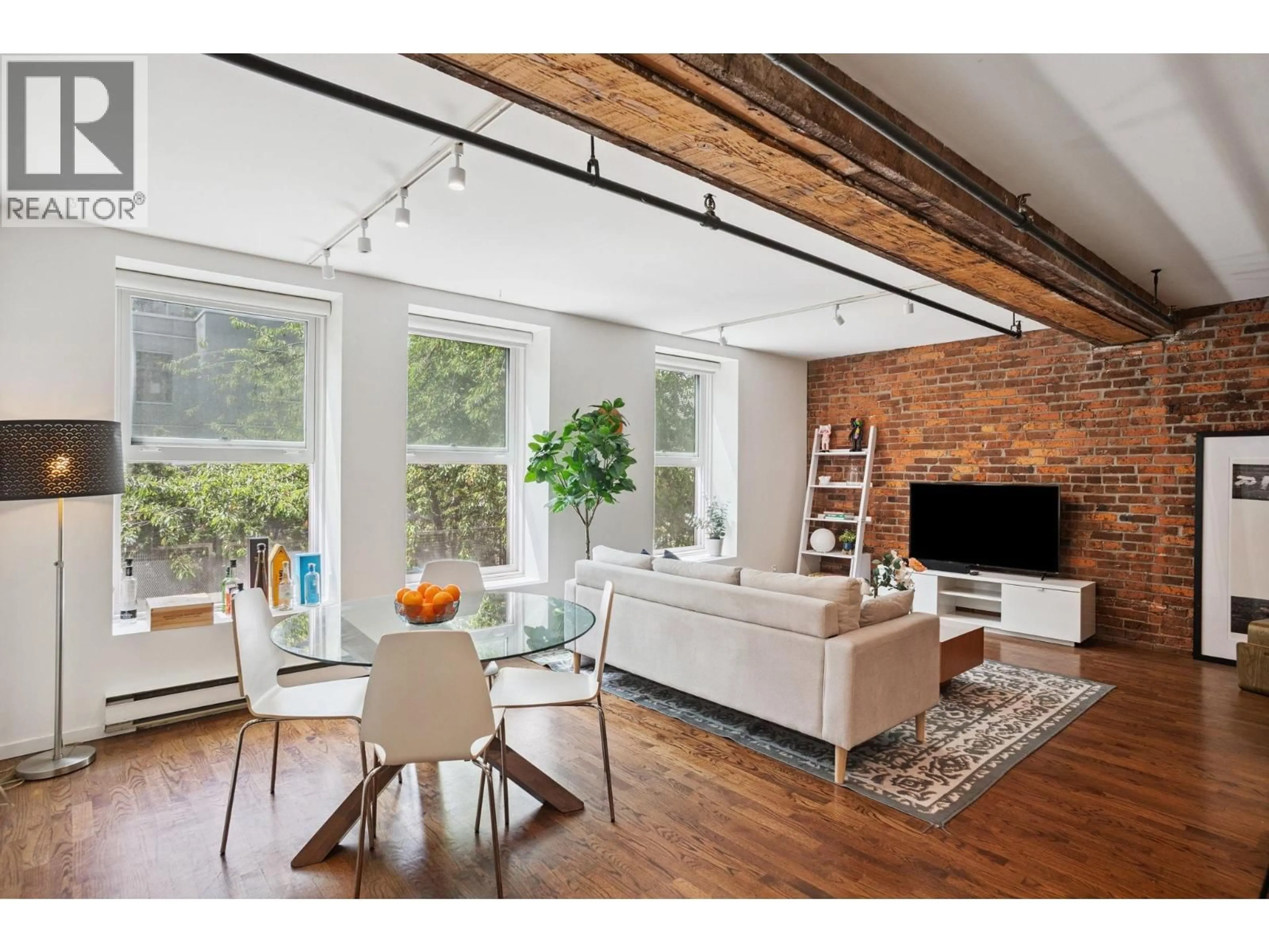 Living room with furniture, wood/laminate floor for 203 - 150 ALEXANDER STREET, Vancouver British Columbia V6A1B5