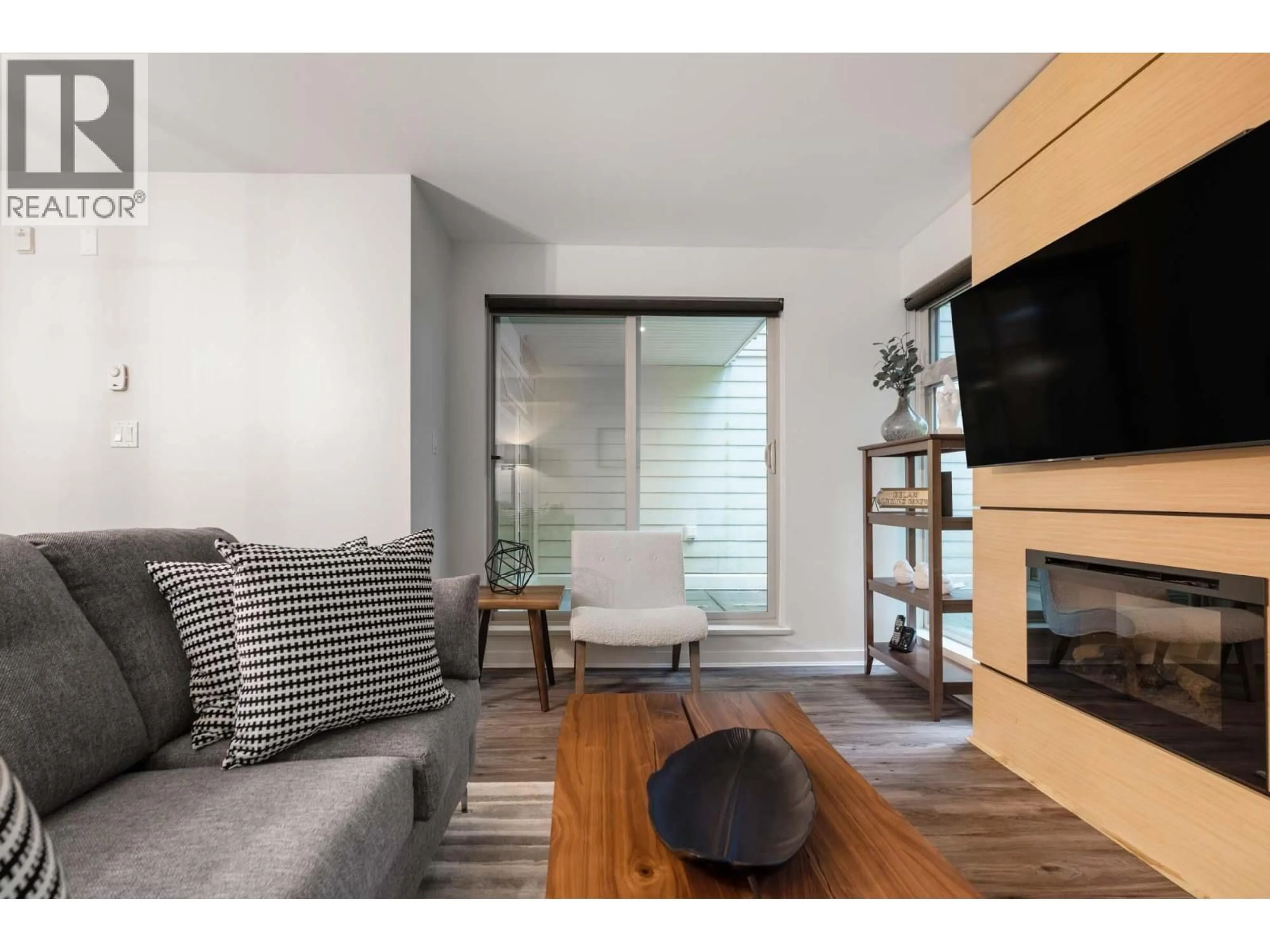 Living room with furniture, wood/laminate floor for 104 - 2832 CAPILANO ROAD, North Vancouver British Columbia V7R4H5