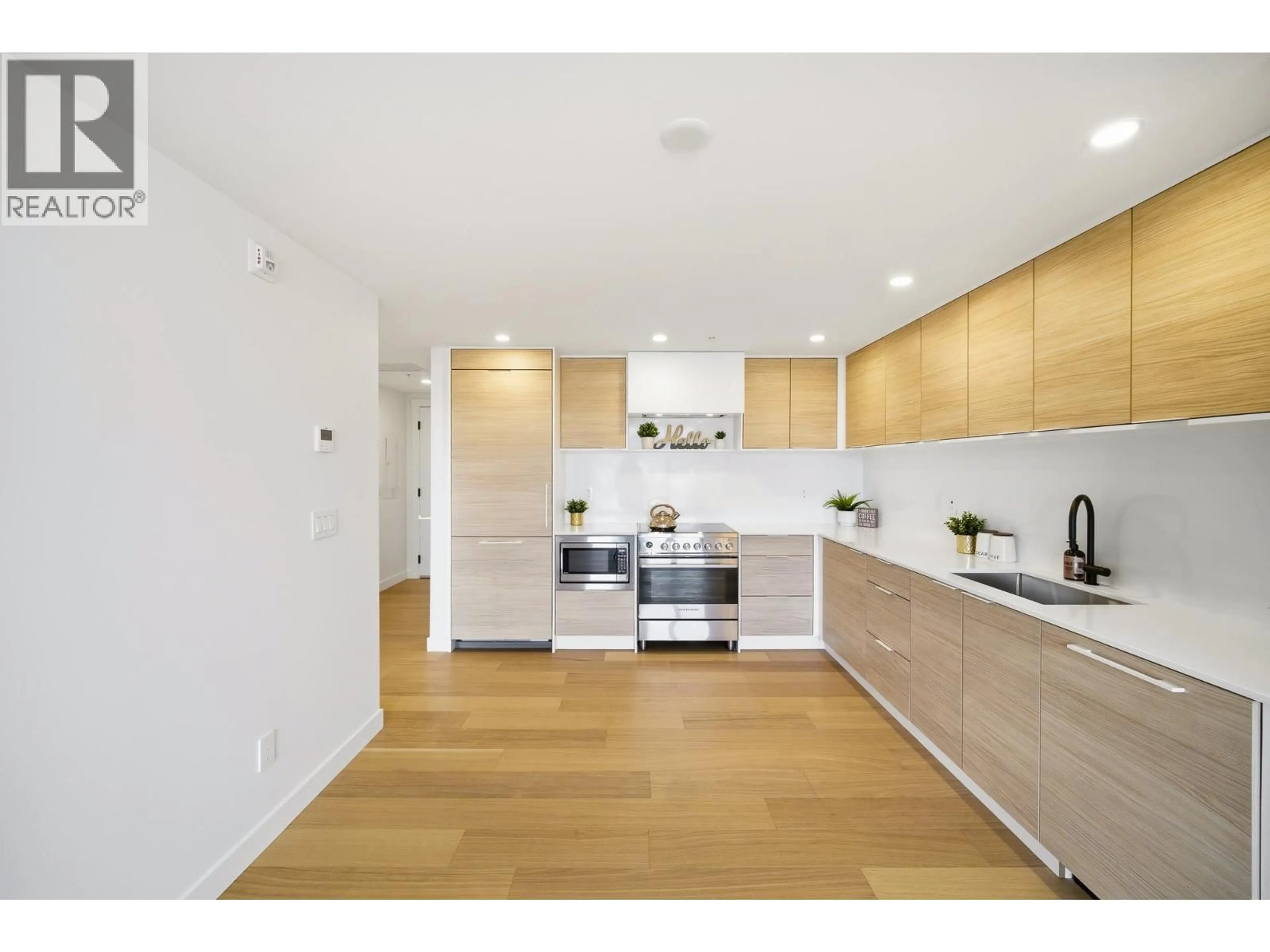 Open concept kitchen, wood/laminate floor for 406 - 6485 MANITOBA STREET, Vancouver British Columbia V5Y0P7
