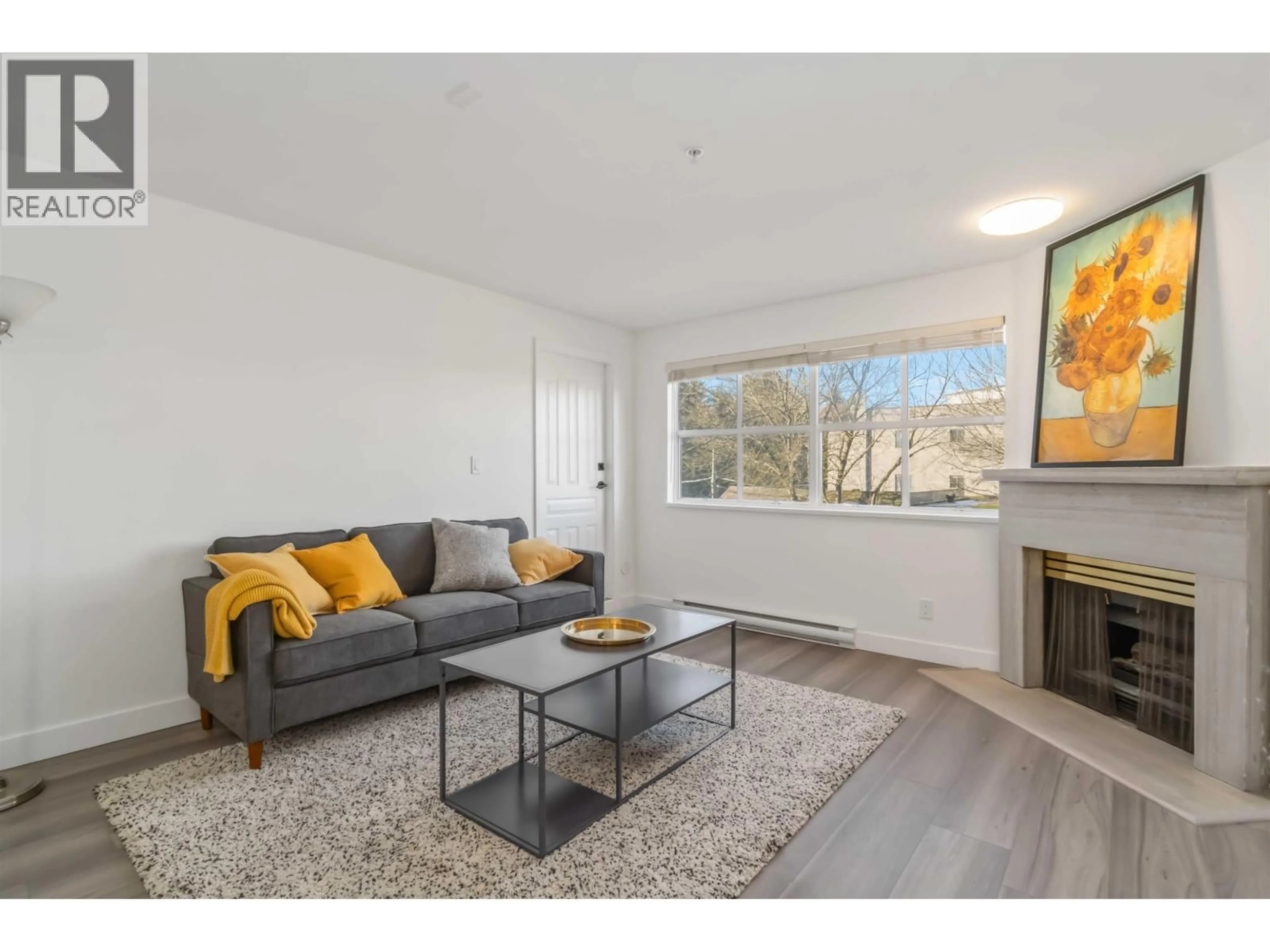 Living room with furniture, wood/laminate floor for 309 - 2928 COMMERCIAL DRIVE, Vancouver British Columbia V5N4C9