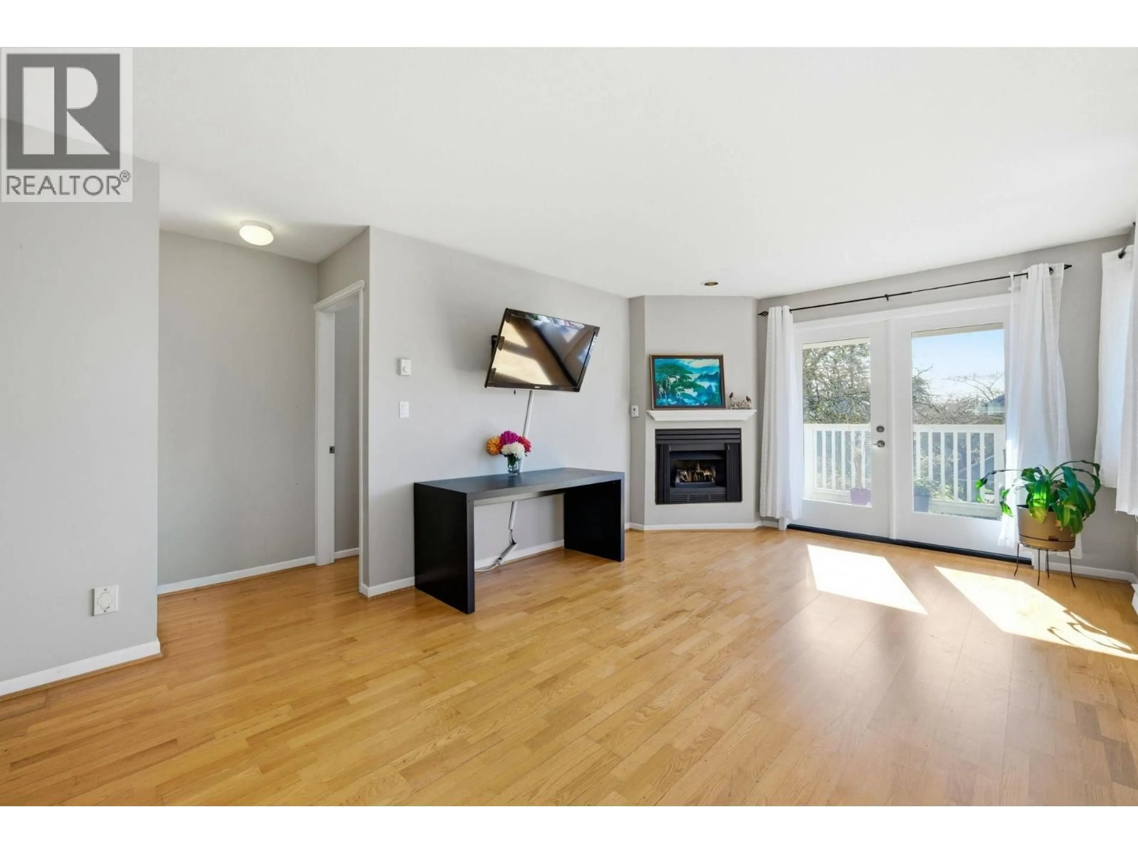 Living room with furniture, wood/laminate floor for 203 - 1538 BOWSER AVENUE, North Vancouver British Columbia V7P2Y3