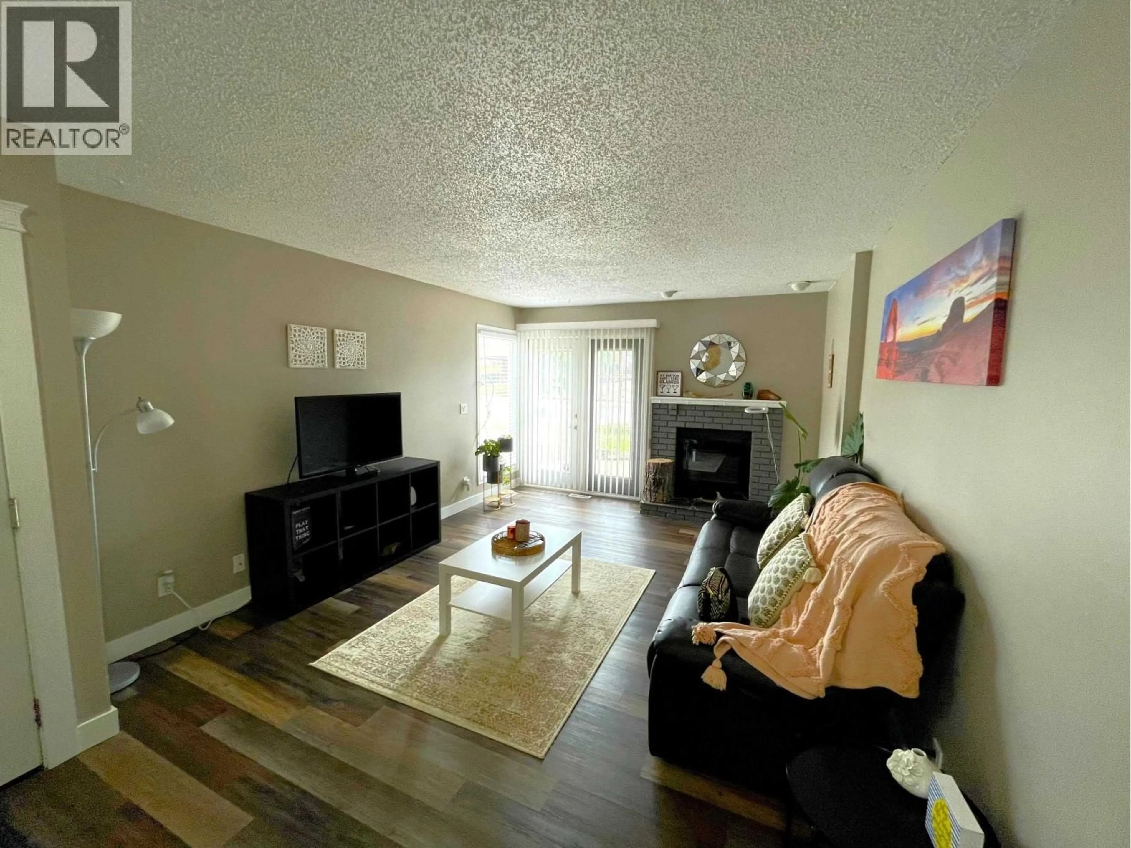 Living room with furniture, wood/laminate floor for 9102 112 AVENUE, Fort St. John British Columbia V1J5H8