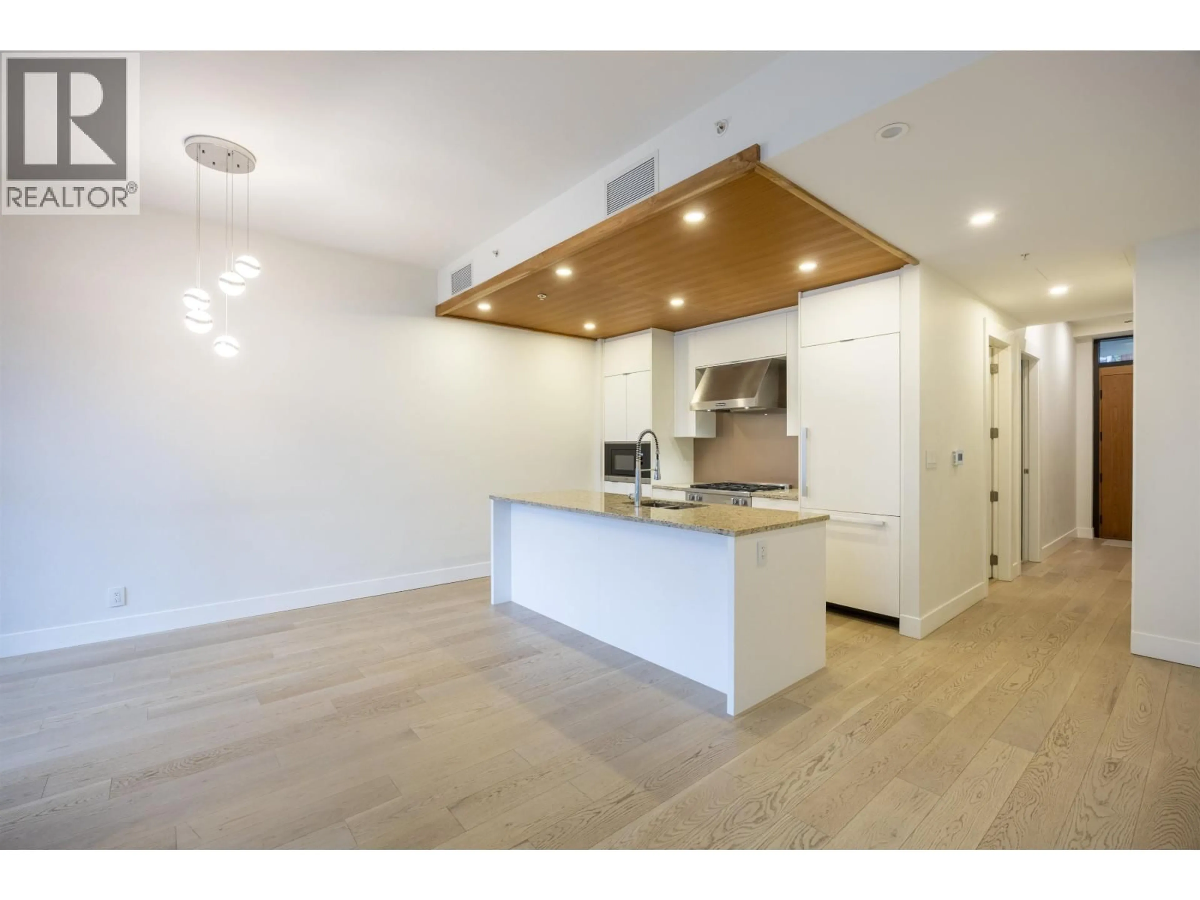 Open concept kitchen, wood/laminate floor for 306 - 6687 NELSON AVENUE, Vancouver British Columbia V7W2B2