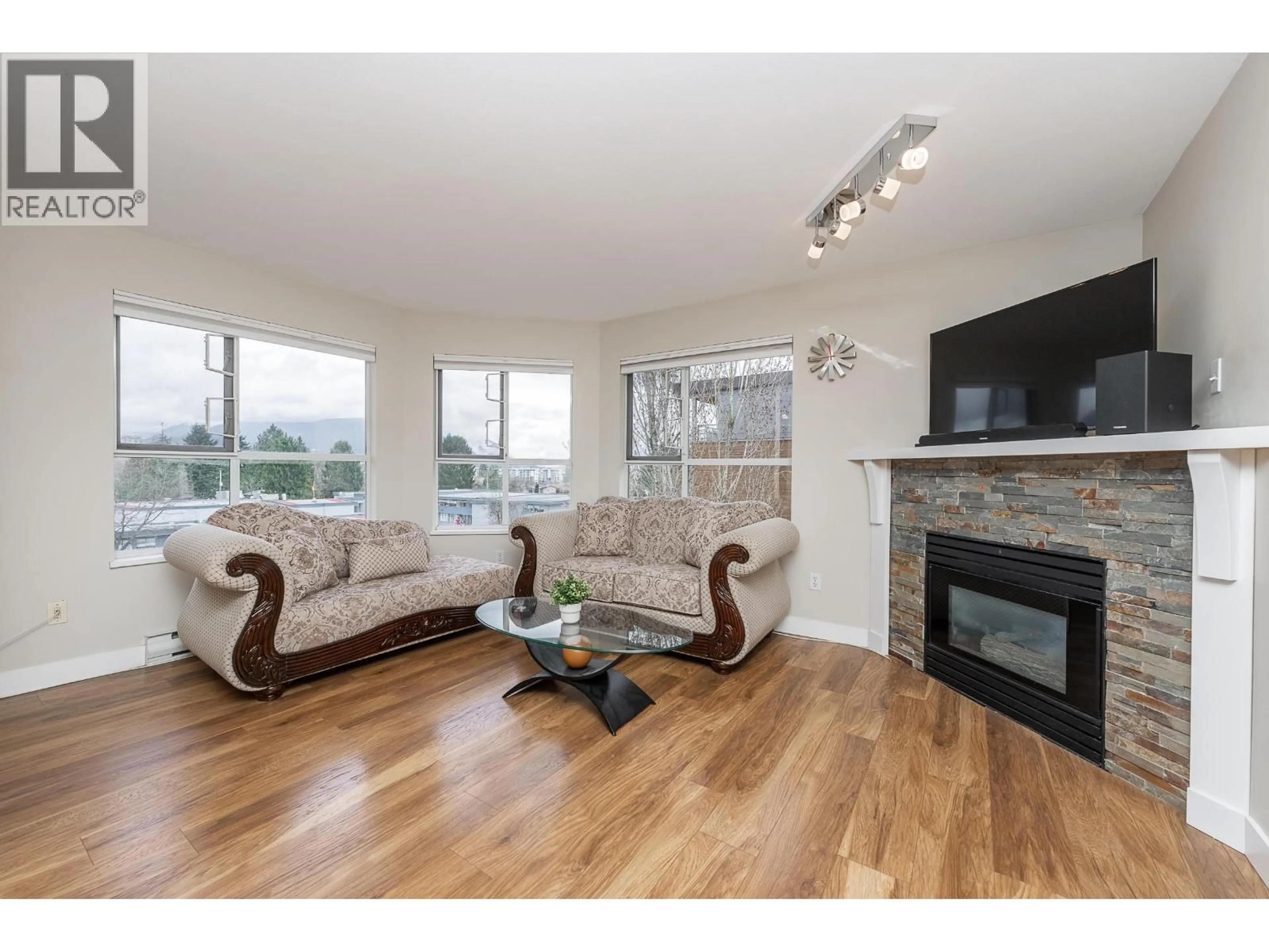 Living room with furniture, wood/laminate floor for 406 - 2285 PITT RIVER ROAD, Port Coquitlam British Columbia V3C1R7