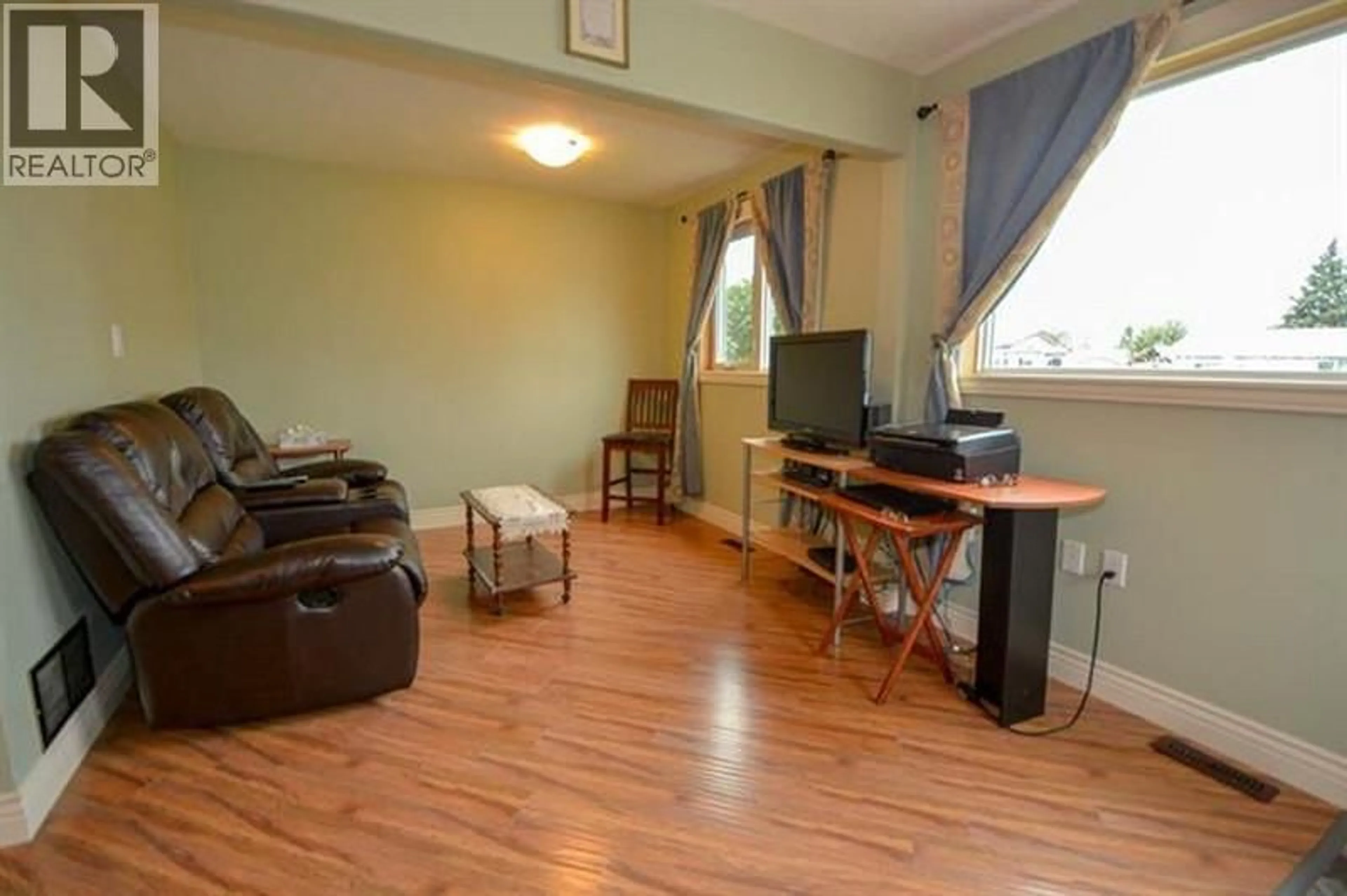 Living room with furniture, wood/laminate floor for 9223 106 AVENUE, Fort St. John British Columbia V1J2N5