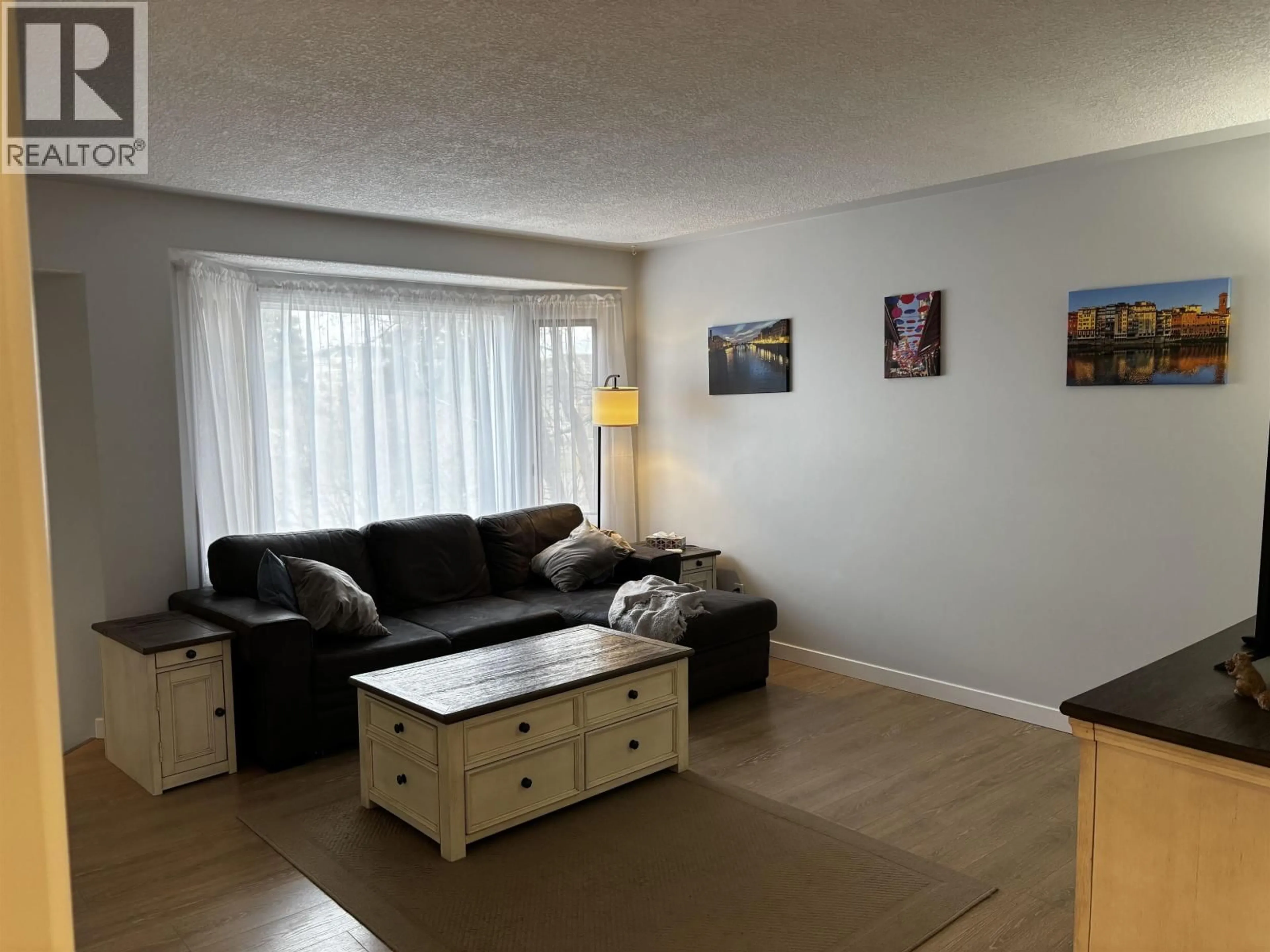Living room with furniture, wood/laminate floor for 9011 99 AVENUE, Fort St. John British Columbia V1J5S2