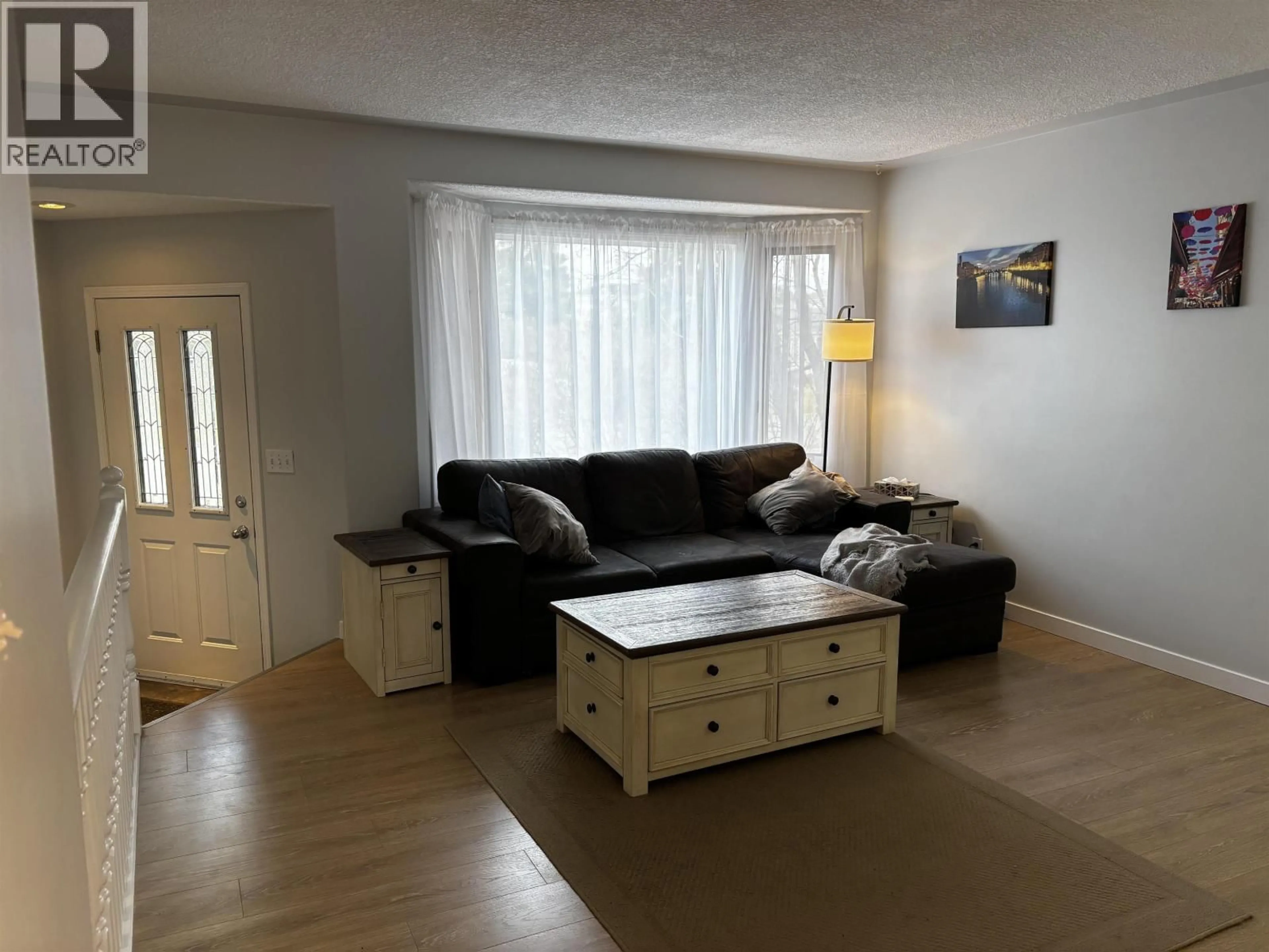 Living room with furniture, wood/laminate floor for 9011 99 AVENUE, Fort St. John British Columbia V1J5S2