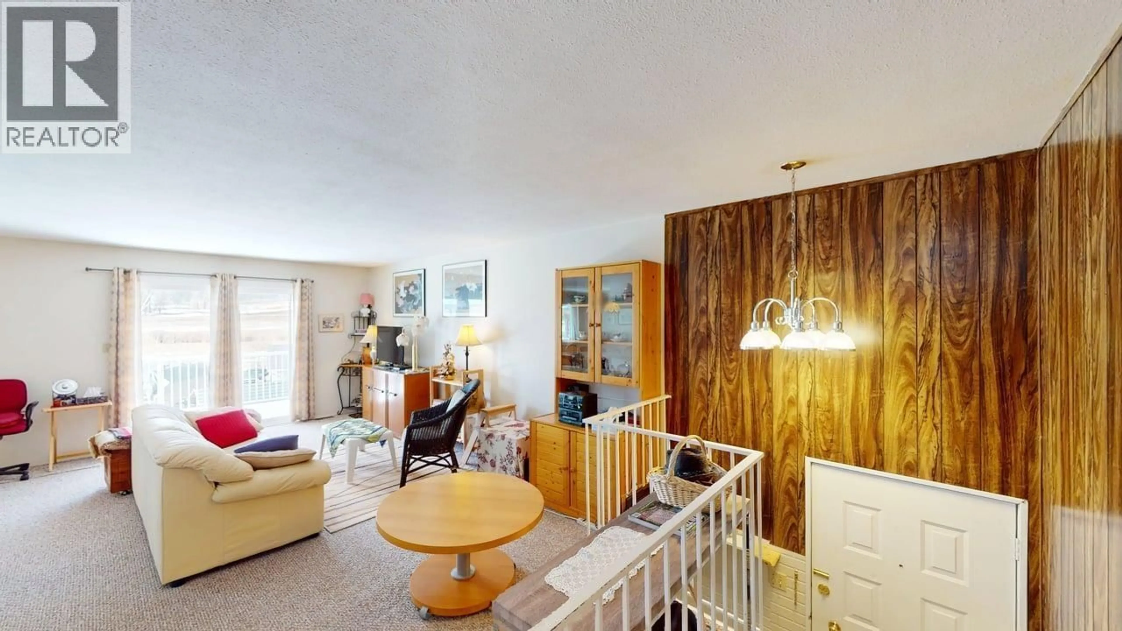 Living room with furniture, wood/laminate floor for 238 ELM AVENUE, 100 Mile House British Columbia V0K2E0