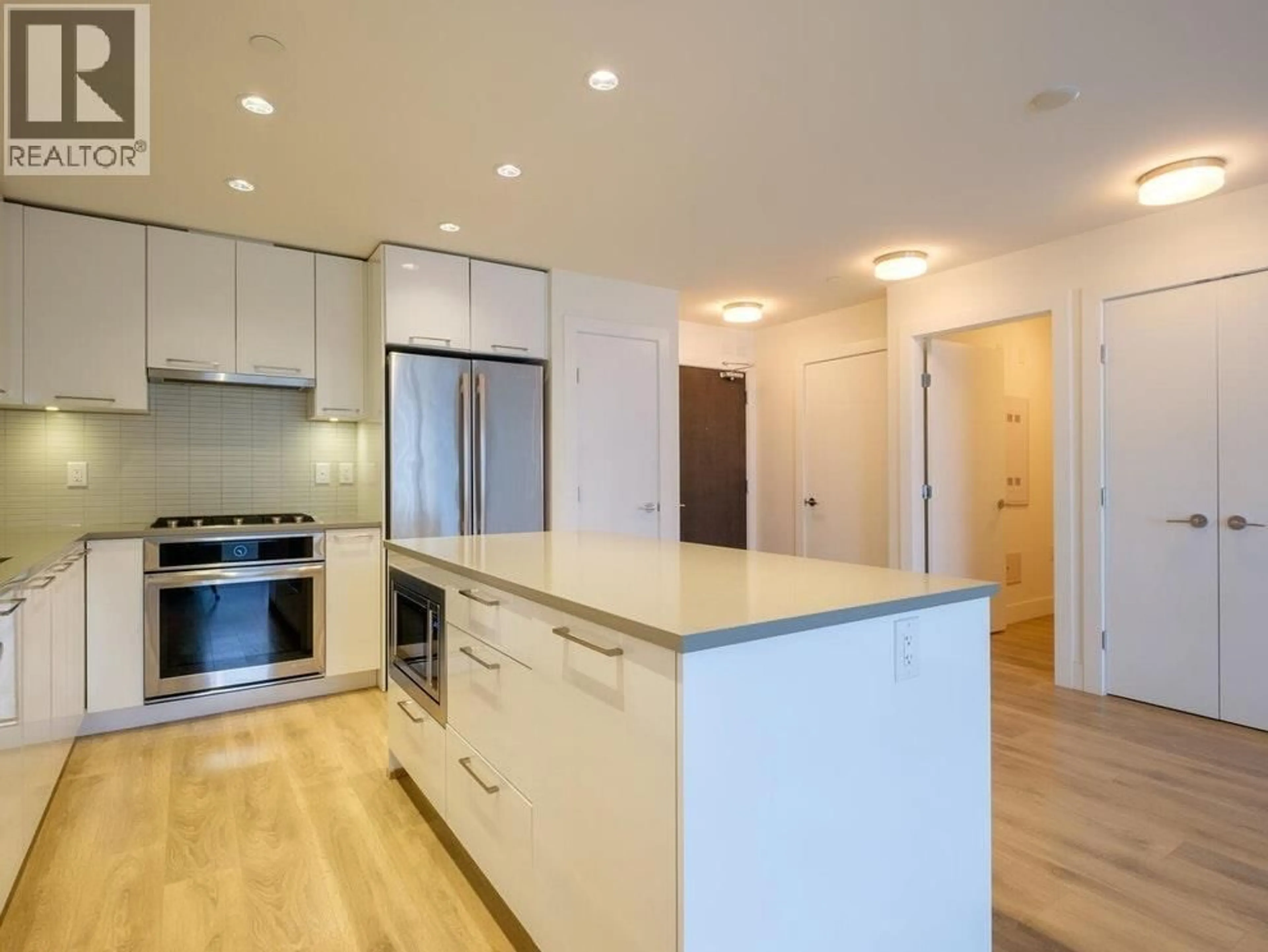 Open concept kitchen, wood/laminate floor for 607 - 3488 SAWMILL CRESCENT, Vancouver British Columbia V5S0C7