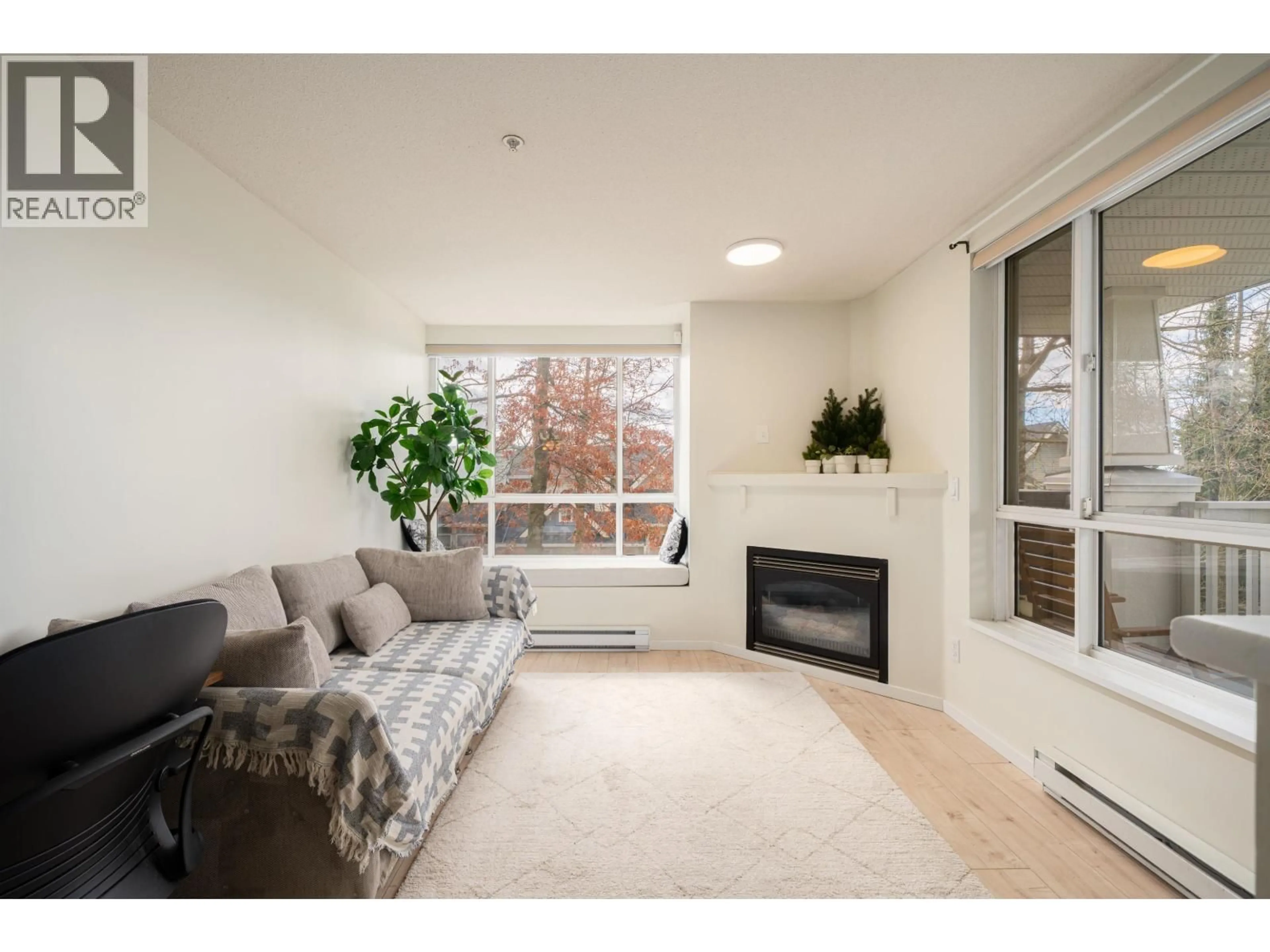 Living room with furniture, wood/laminate floor for 204 - 6833 VILLAGE, Burnaby British Columbia V5E4M1