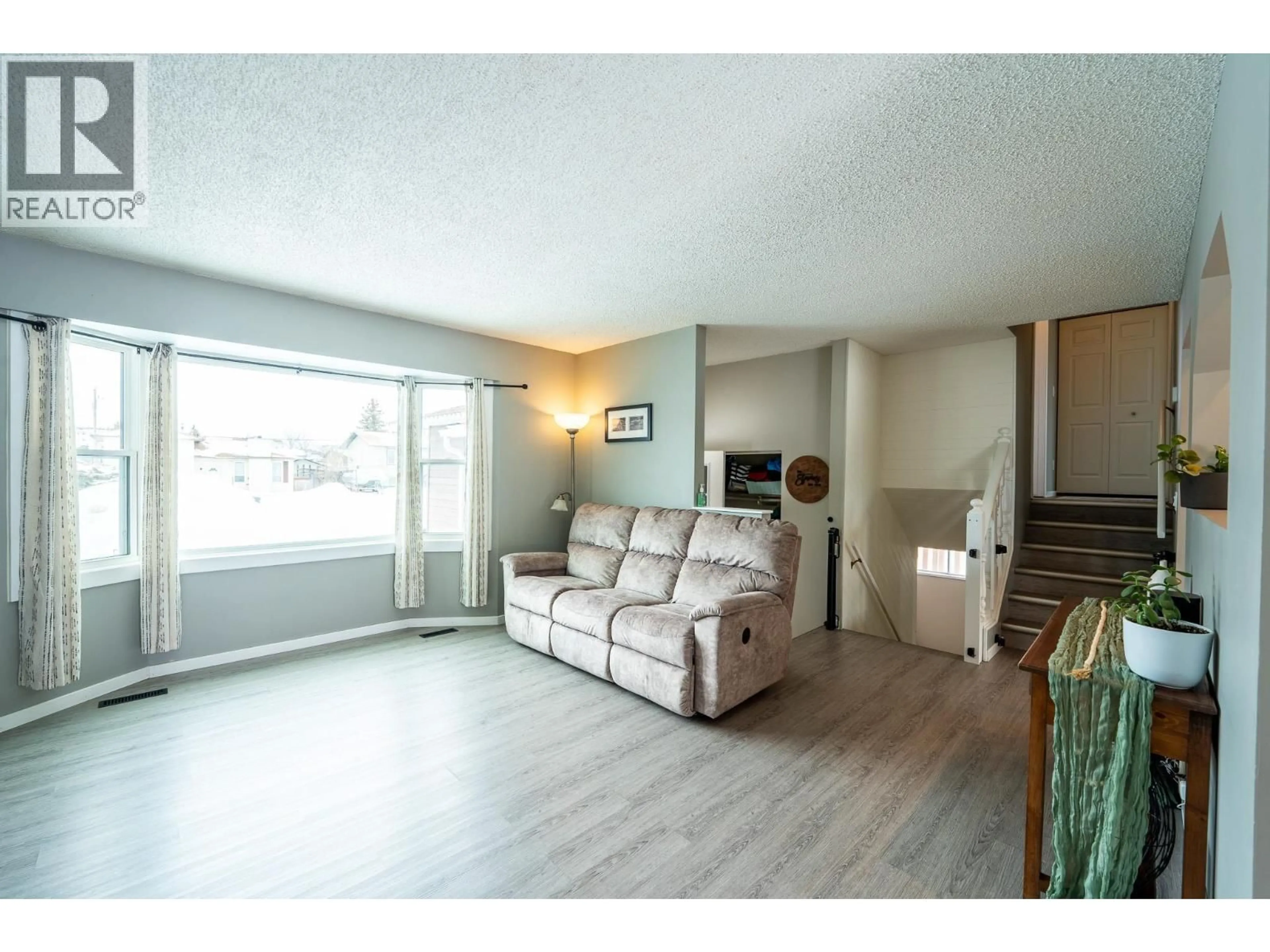 Living room with furniture, wood/laminate floor for 8612 88 STREET, Fort St. John British Columbia V1J6B3