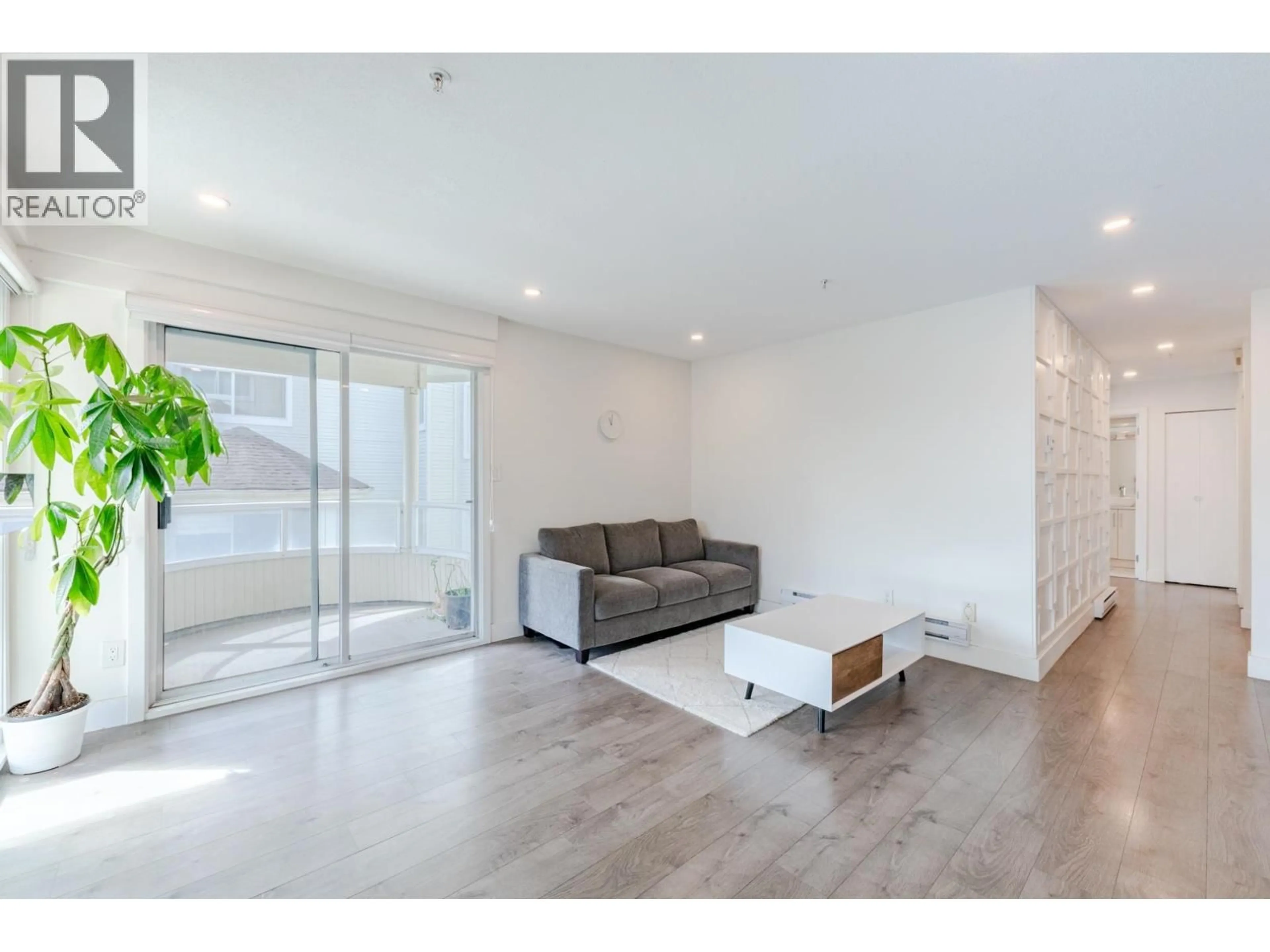 Living room with furniture, wood/laminate floor for 208 - 7620 COLUMBIA STREET, Vancouver British Columbia V5X4S8