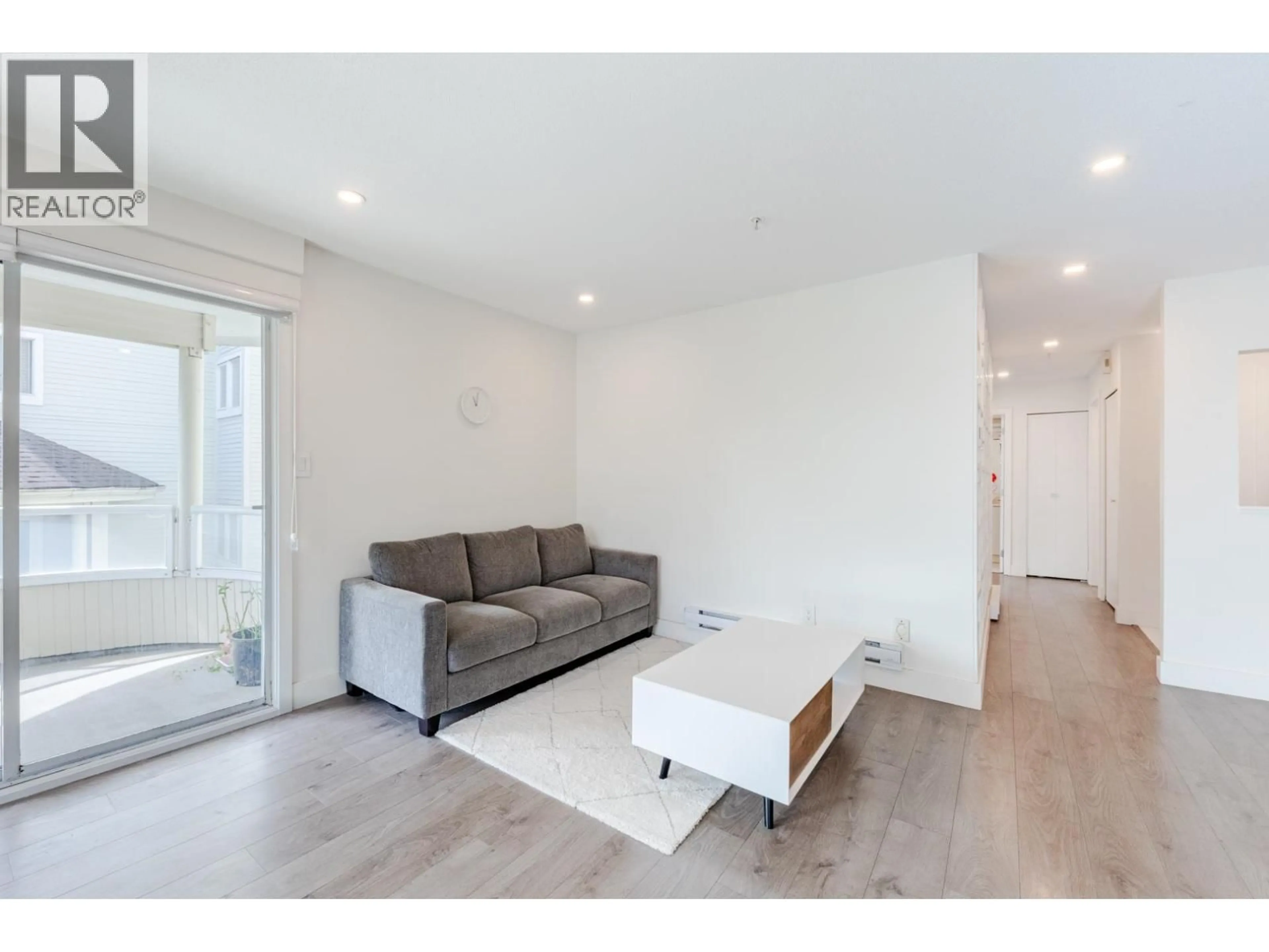 Living room with furniture, wood/laminate floor for 208 - 7620 COLUMBIA STREET, Vancouver British Columbia V5X4S8
