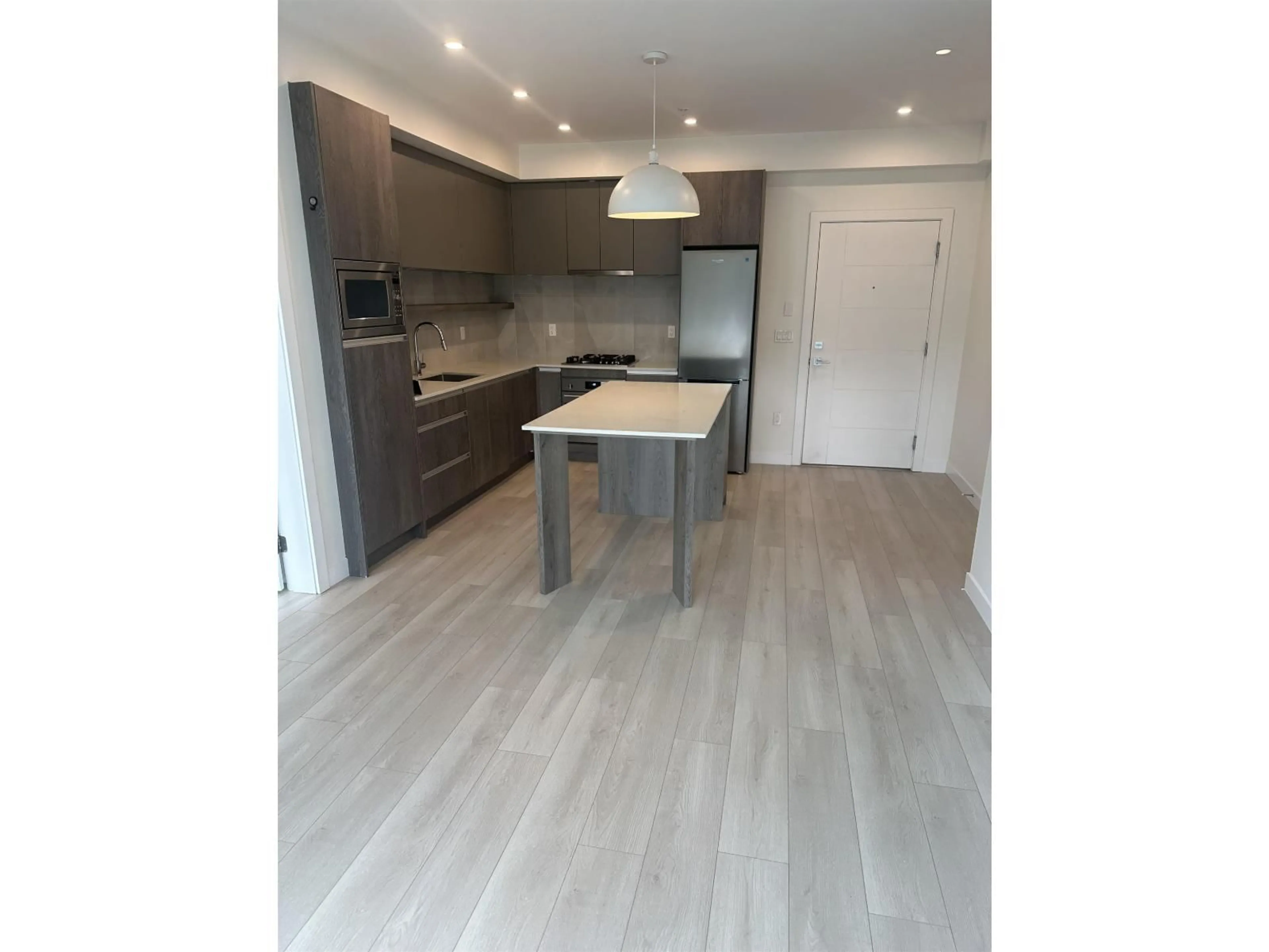 Open concept kitchen, wood/laminate floor for 407 - 14225 103A AVENUE, Surrey British Columbia V3T0T4