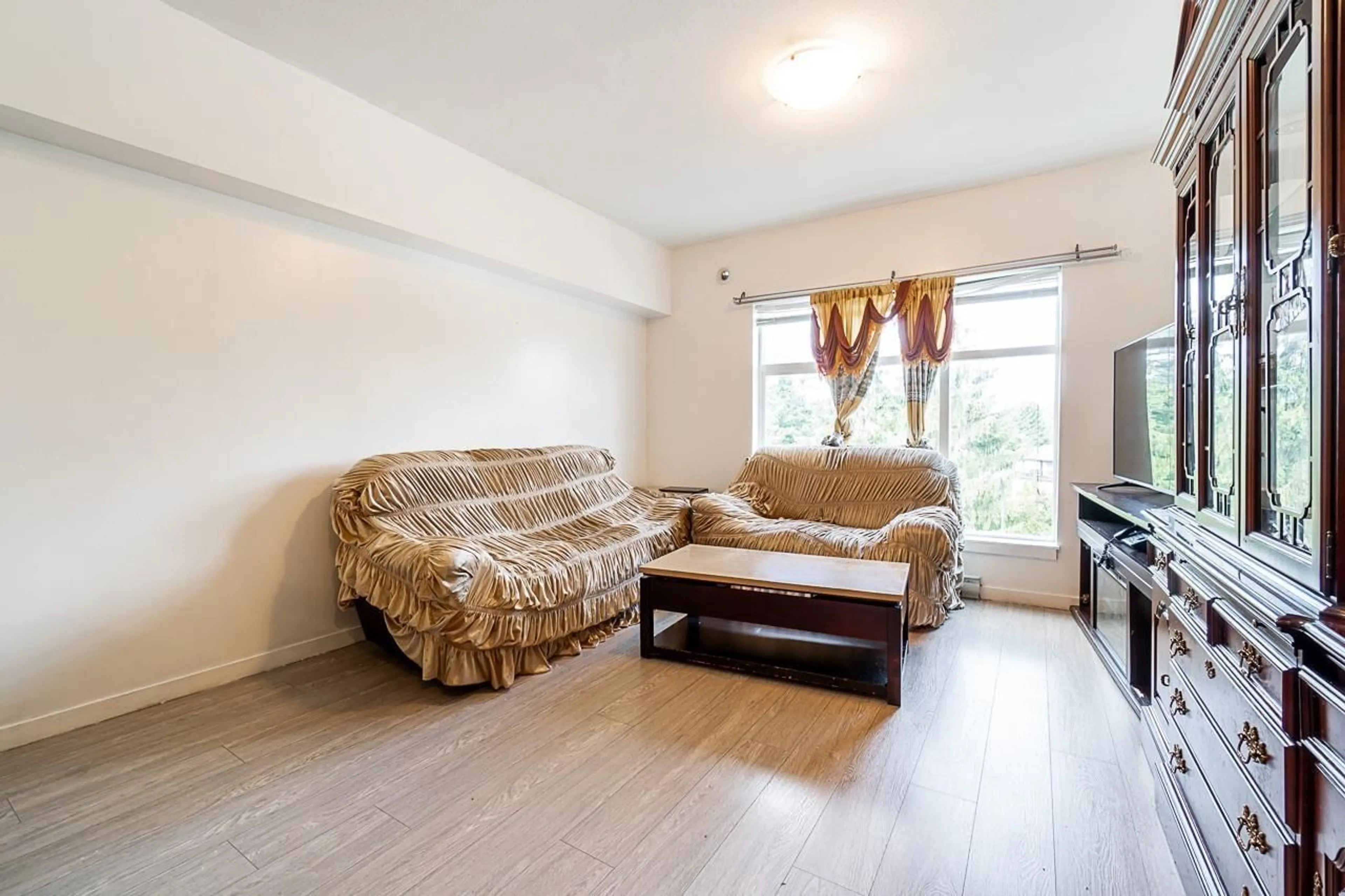 Living room with furniture, wood/laminate floor for 401 - 13728 108 AVENUE, Surrey British Columbia V3T0B7