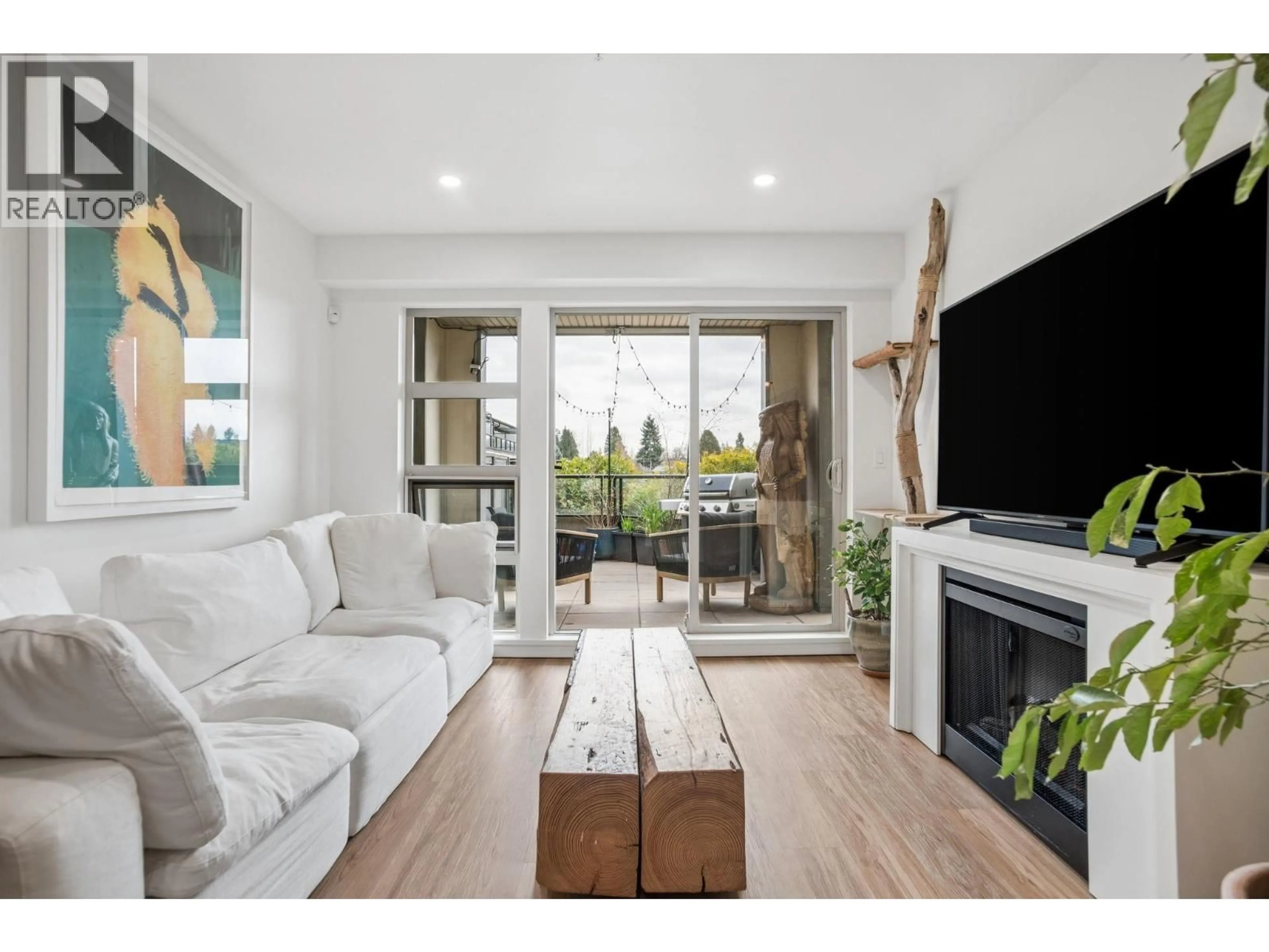 Living room with furniture, wood/laminate floor for 218 - 4550 FRASER STREET, Vancouver British Columbia V5V4G8