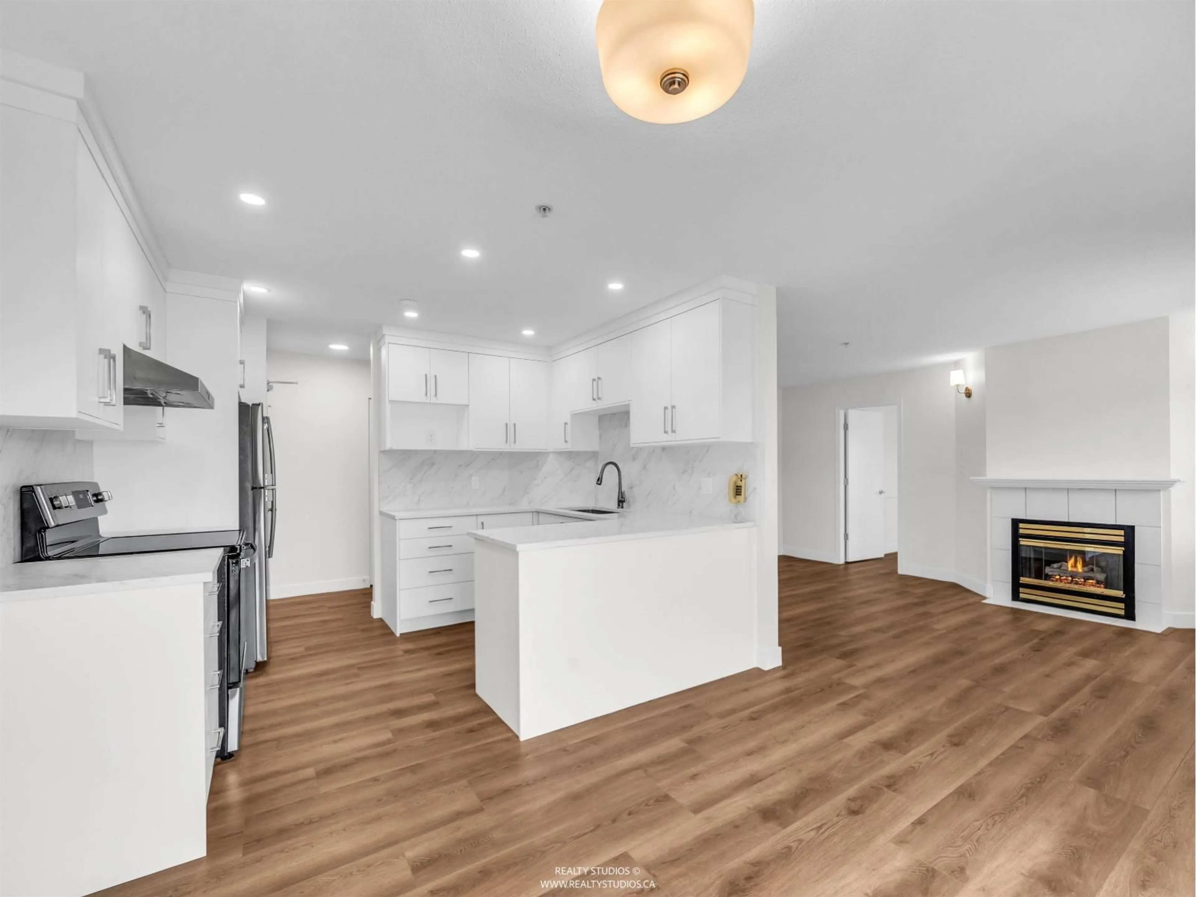 Open concept kitchen, wood/laminate floor for 402 - 12130 80 AVENUE, Surrey British Columbia V3W0V2