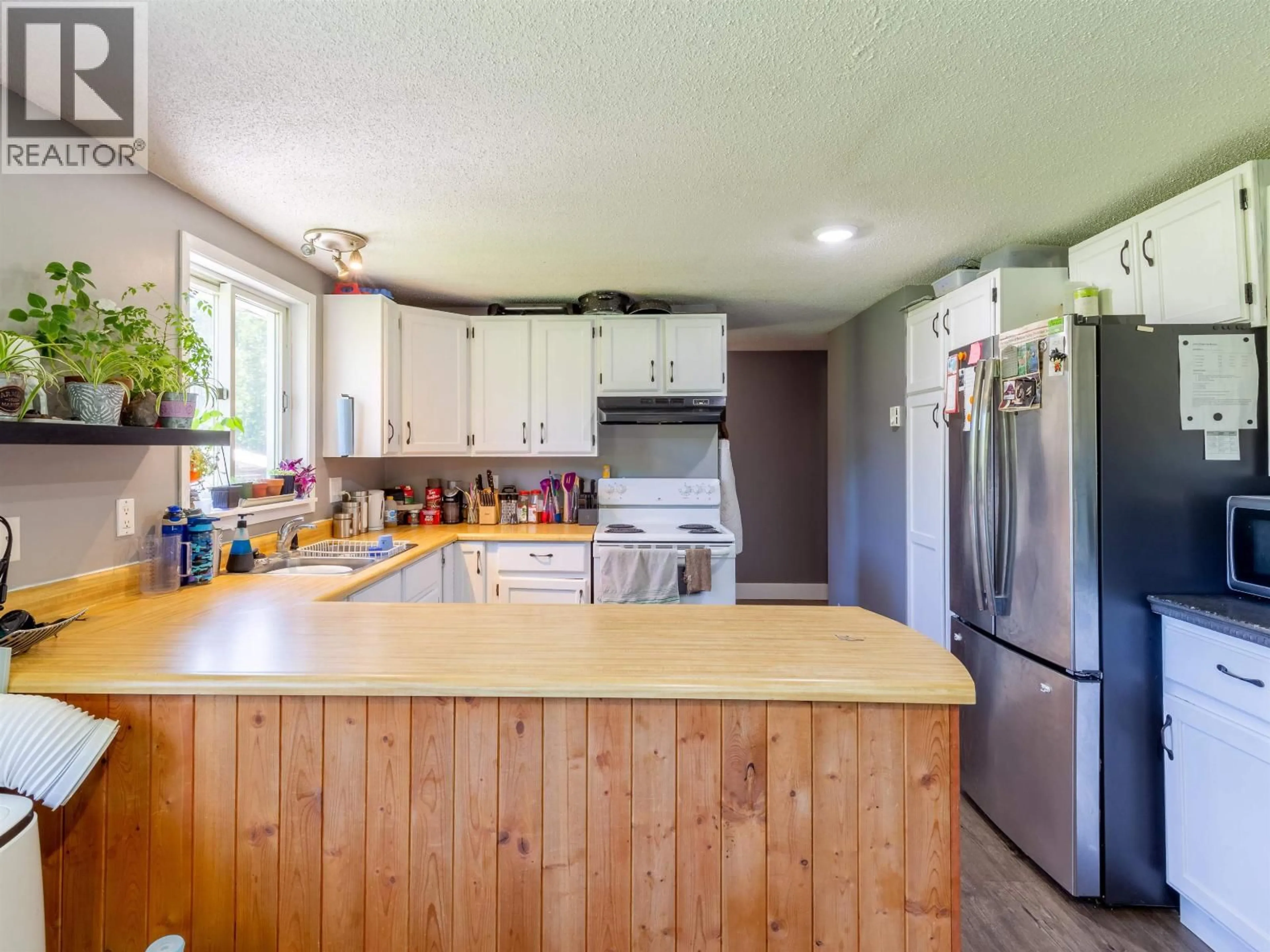 Open concept kitchen, wood/laminate floor for 5933 RACEWAY ROAD, Smithers British Columbia V0J2N1