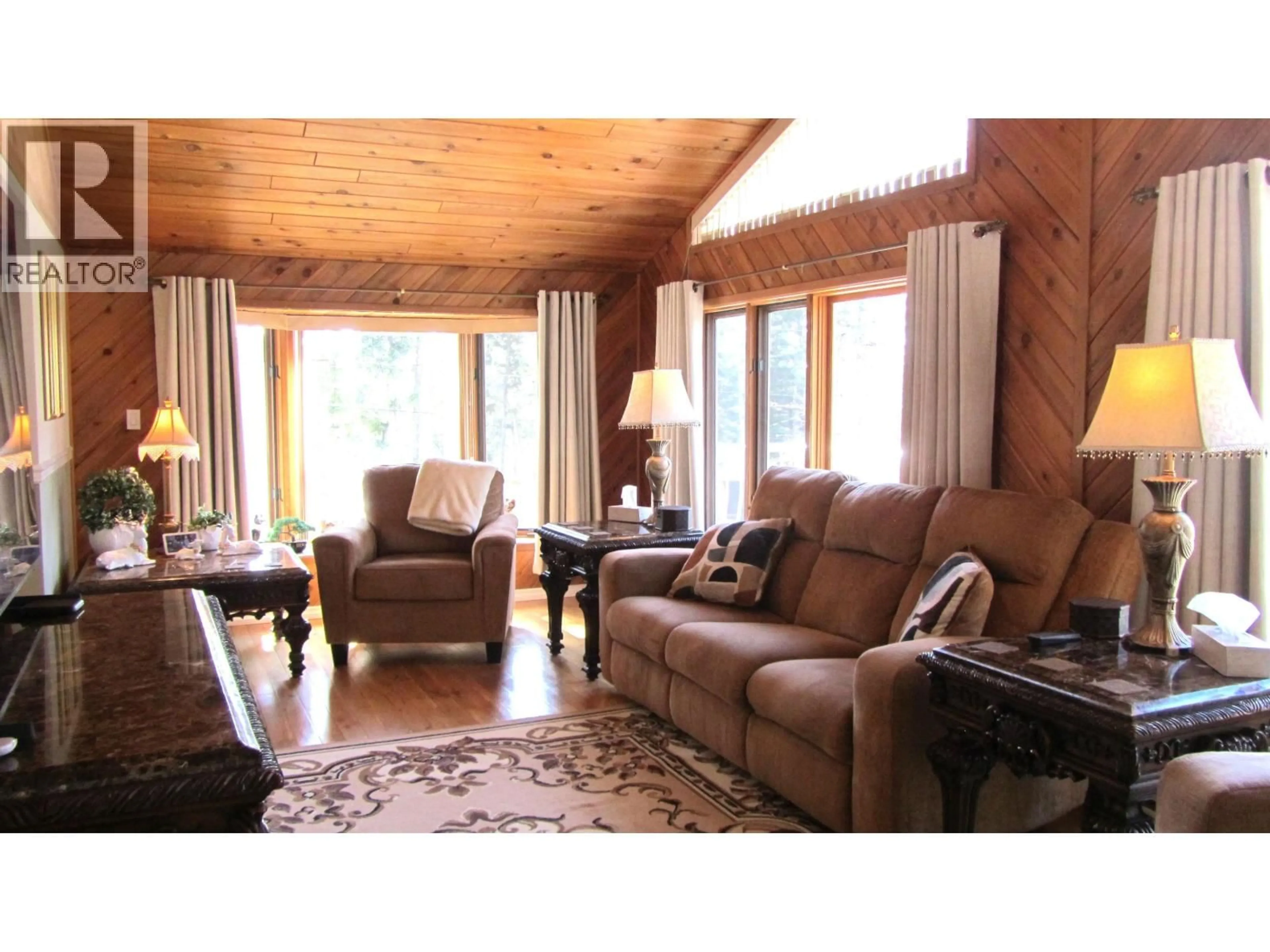 Living room with furniture, wood/laminate floor for 4827 KITWANGA DRIVE, 108 Mile Ranch British Columbia V0K2Z0