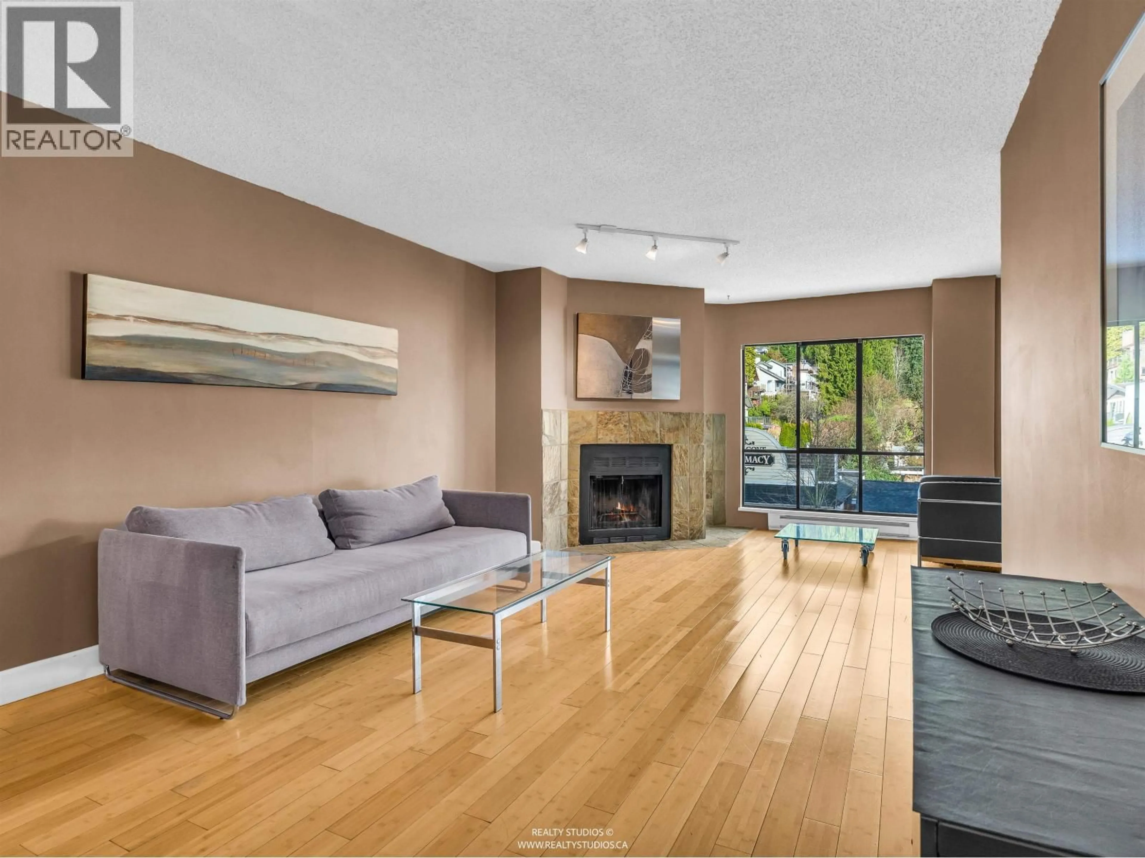 Living room with furniture, wood/laminate floor for 203 - 4323 GALLANT AVENUE, North Vancouver British Columbia V7G2C1