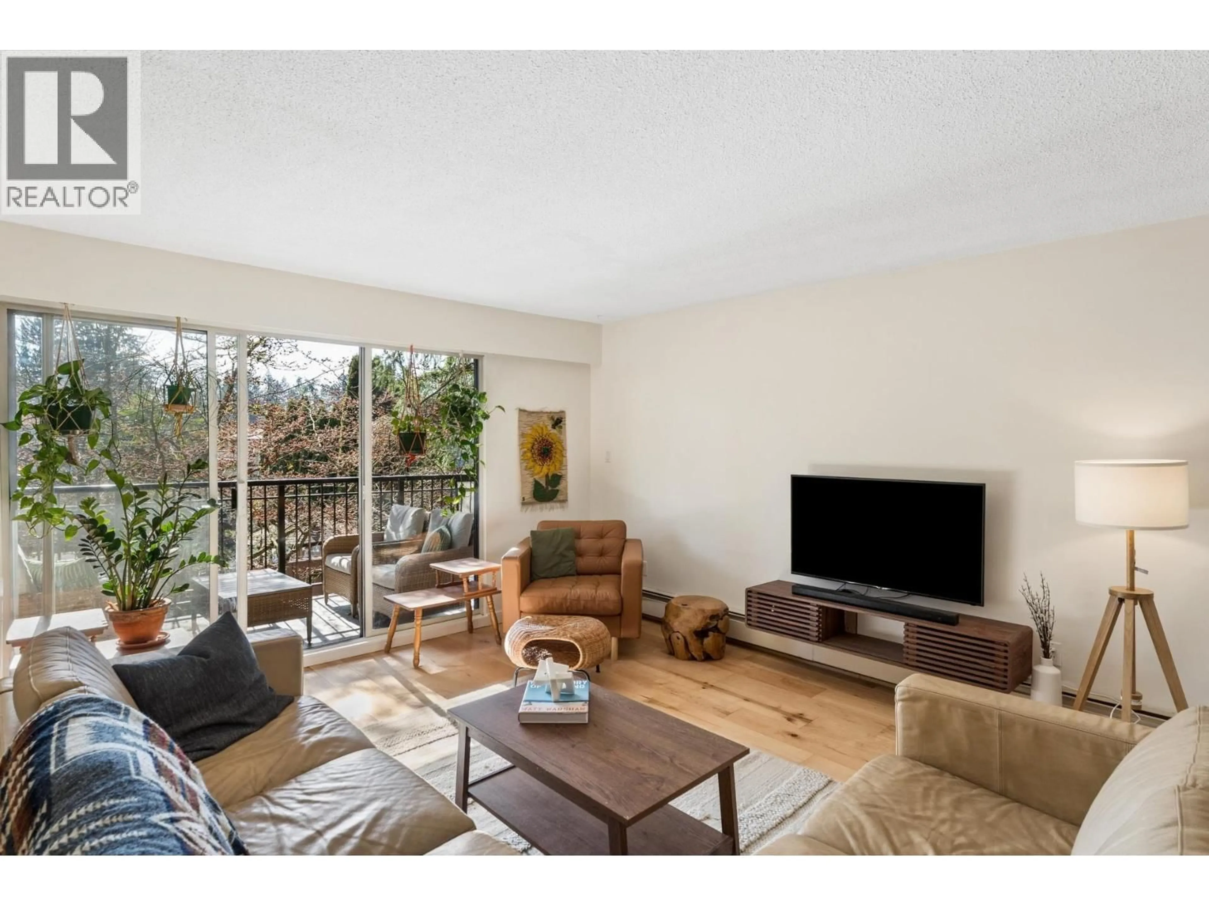 Living room with furniture, wood/laminate floor for 211 - 1385 DRAYCOTT ROAD, North Vancouver British Columbia V7J3K9