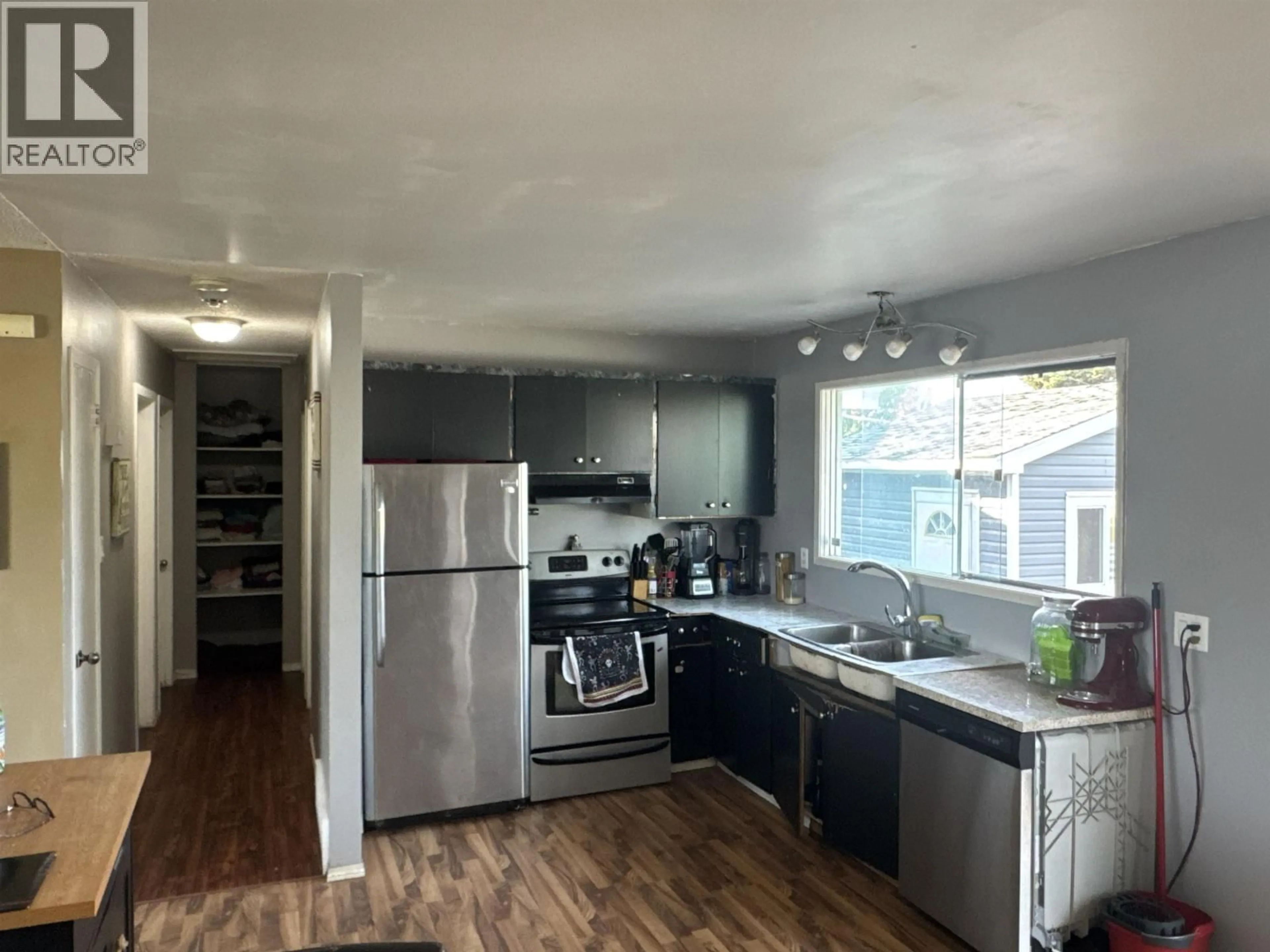 Open concept kitchen, wood/laminate floor for 9808 112 AVENUE, Fort St. John British Columbia V1J2W5