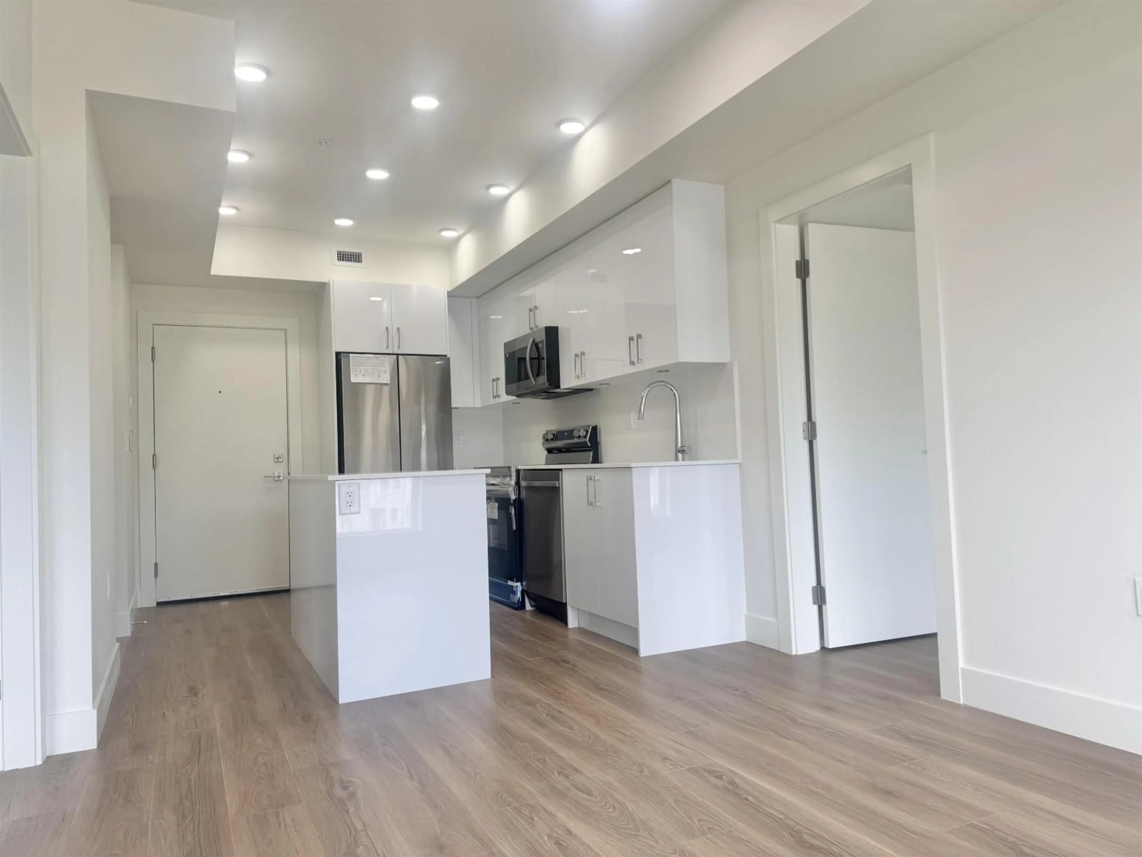 Open concept kitchen, wood/laminate floor for 303 - 15739 FRASER HIGHWAY, Surrey British Columbia V4N6Y4