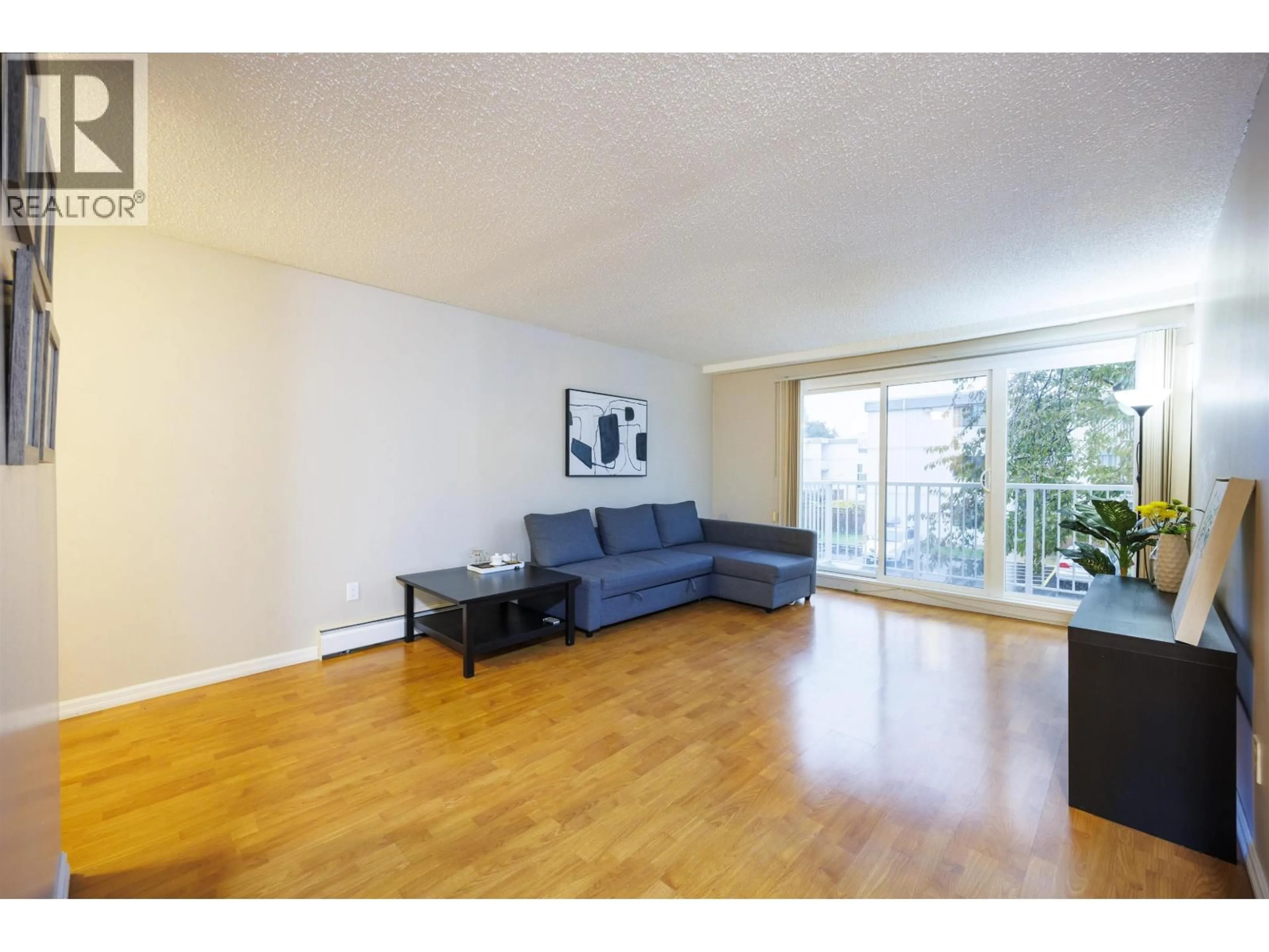 Living room with furniture, wood/laminate floor for 201 - 7200 LINDSAY ROAD, Richmond British Columbia V7C3M6