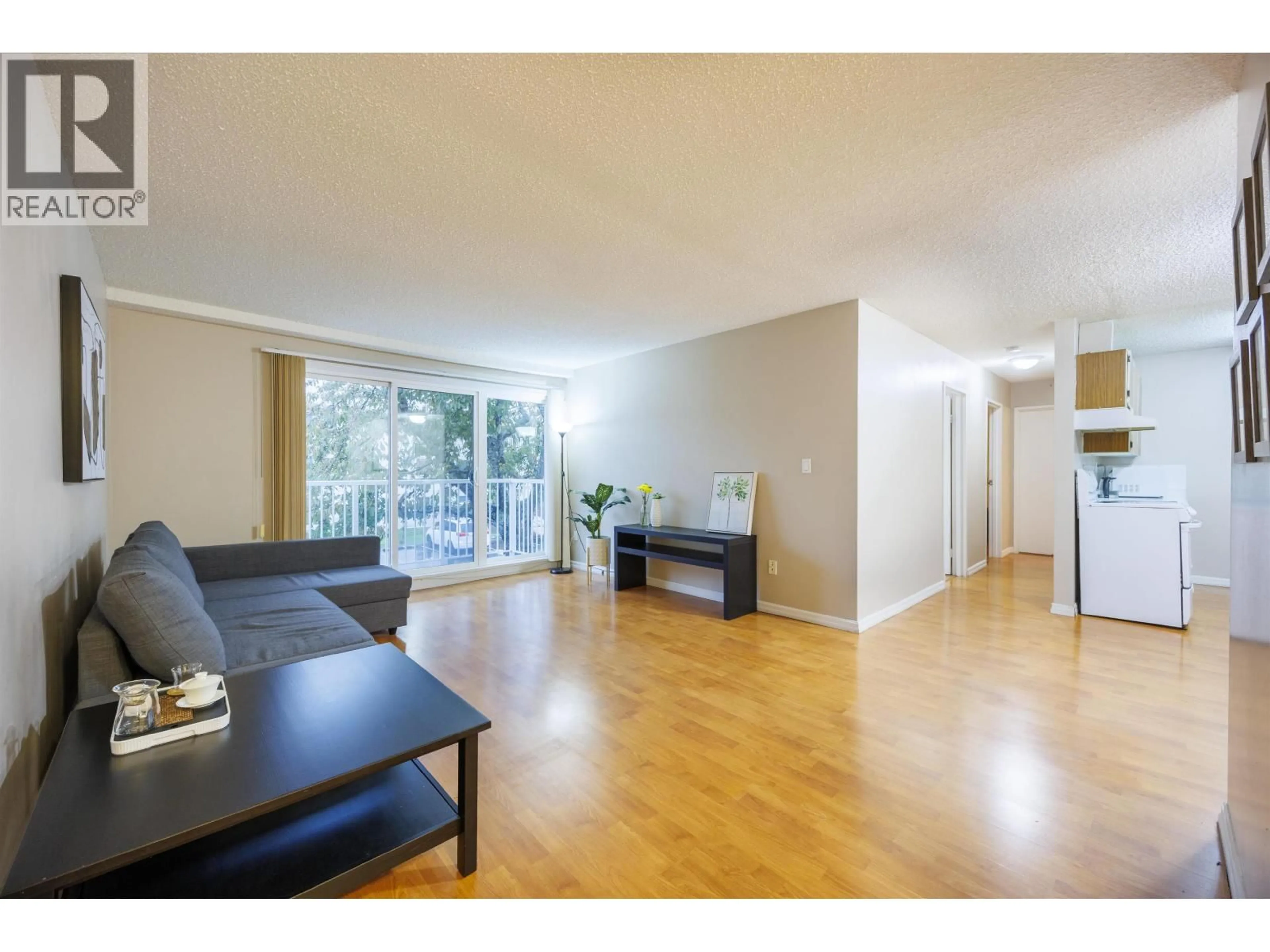 Living room with furniture, wood/laminate floor for 201 - 7200 LINDSAY ROAD, Richmond British Columbia V7C3M6