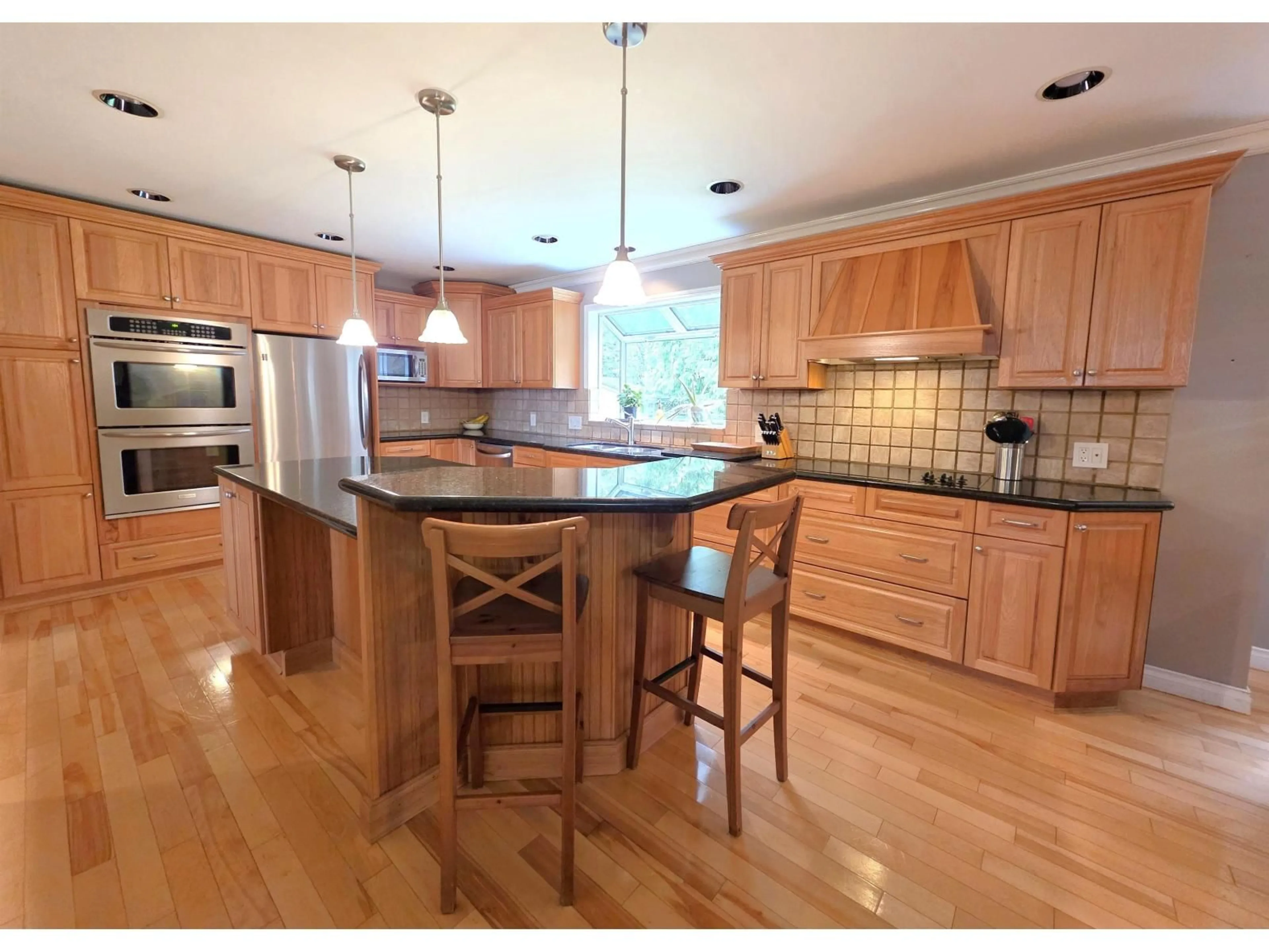 Open concept kitchen, wood/laminate floor for 8412 213TH STREET, Langley British Columbia V1M2J1
