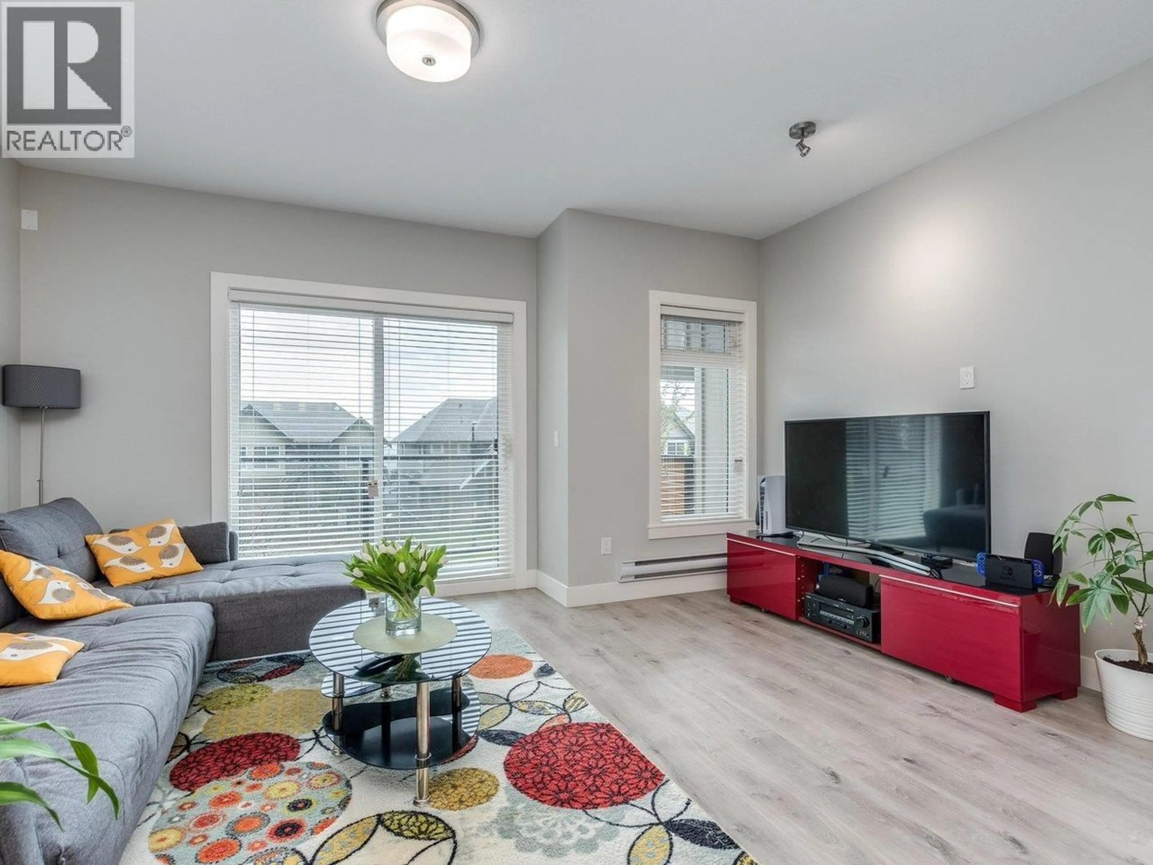 Living room with furniture, wood/laminate floor for 107 - 3525 CHANDLER STREET, Coquitlam British Columbia V3E0L9