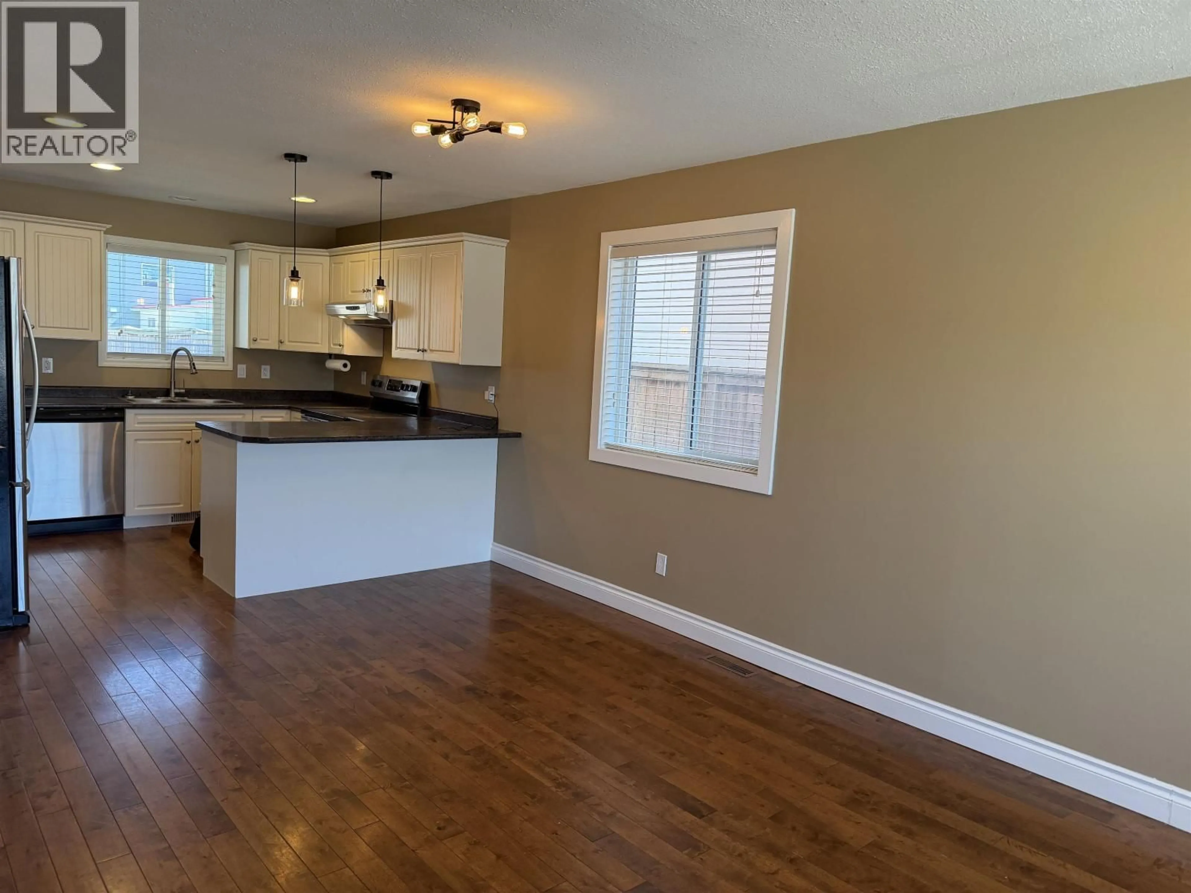 Open concept kitchen, wood/laminate floor for 8403 87 STREET, Fort St. John British Columbia V1J0H4