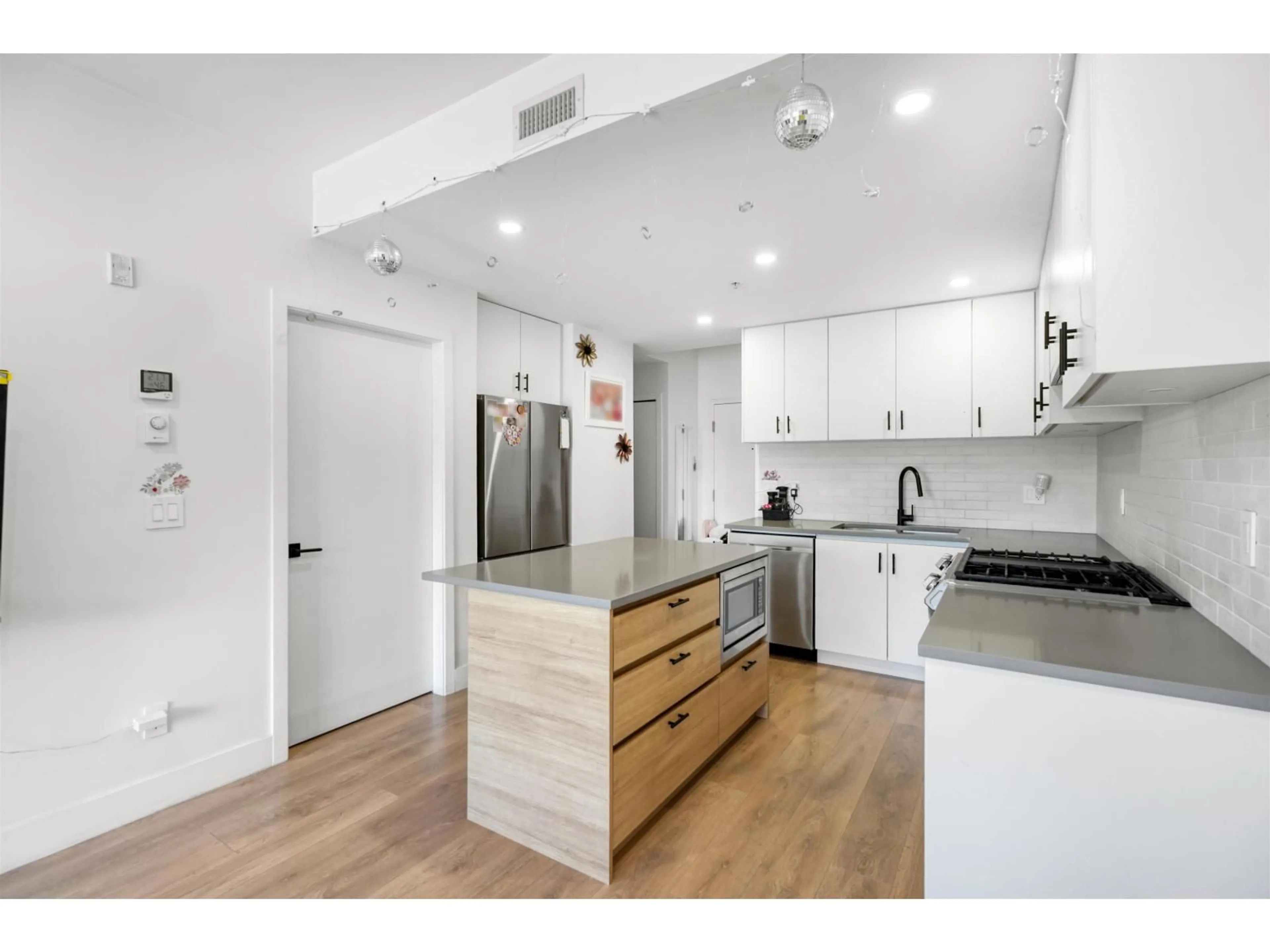 Open concept kitchen, wood/laminate floor for 312 - 8496 120 STREET, Surrey British Columbia V3W3N5