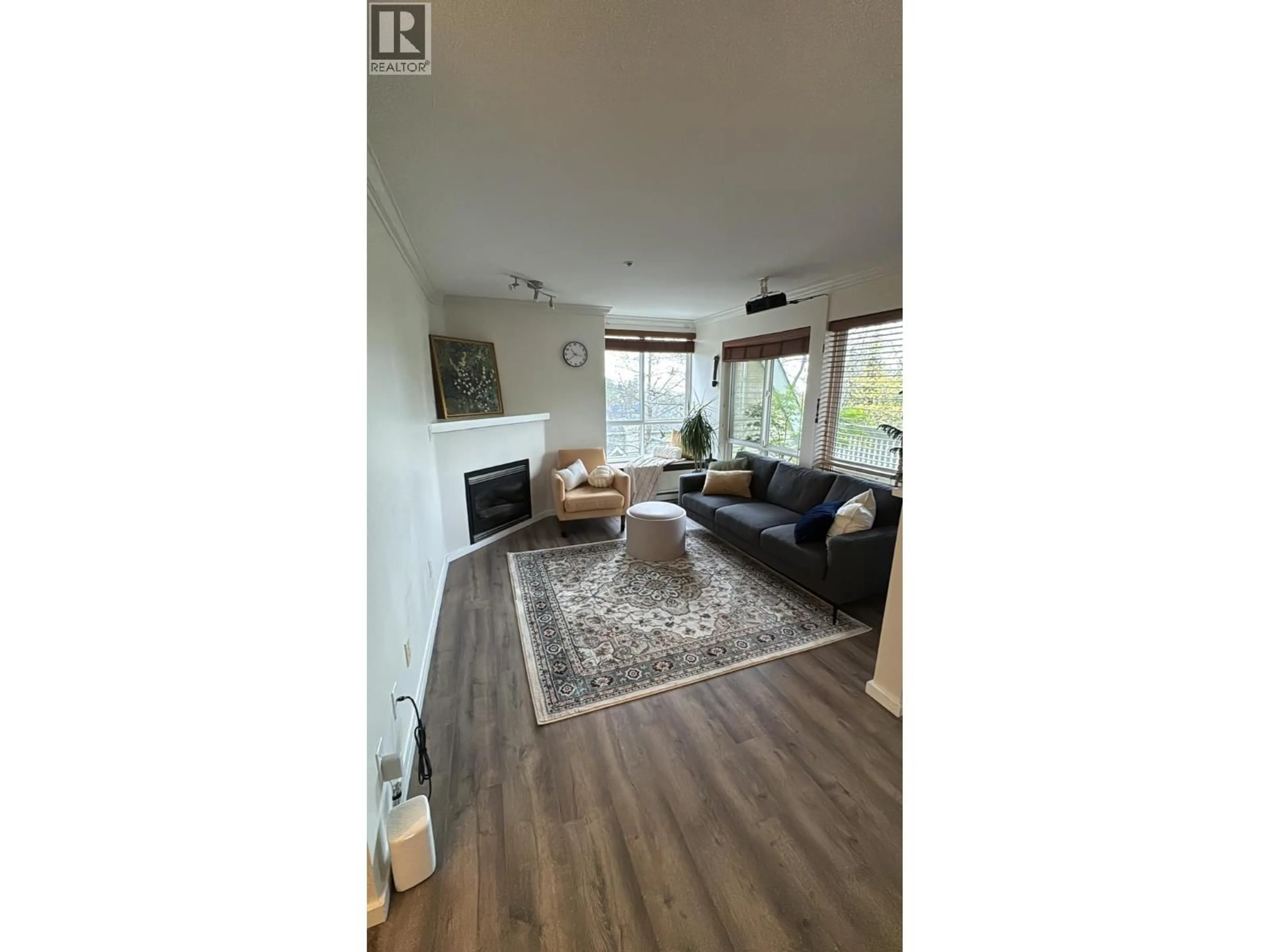 Living room with furniture, wood/laminate floor for 304 - 6833 VILLAGE, Burnaby British Columbia V5E4M1