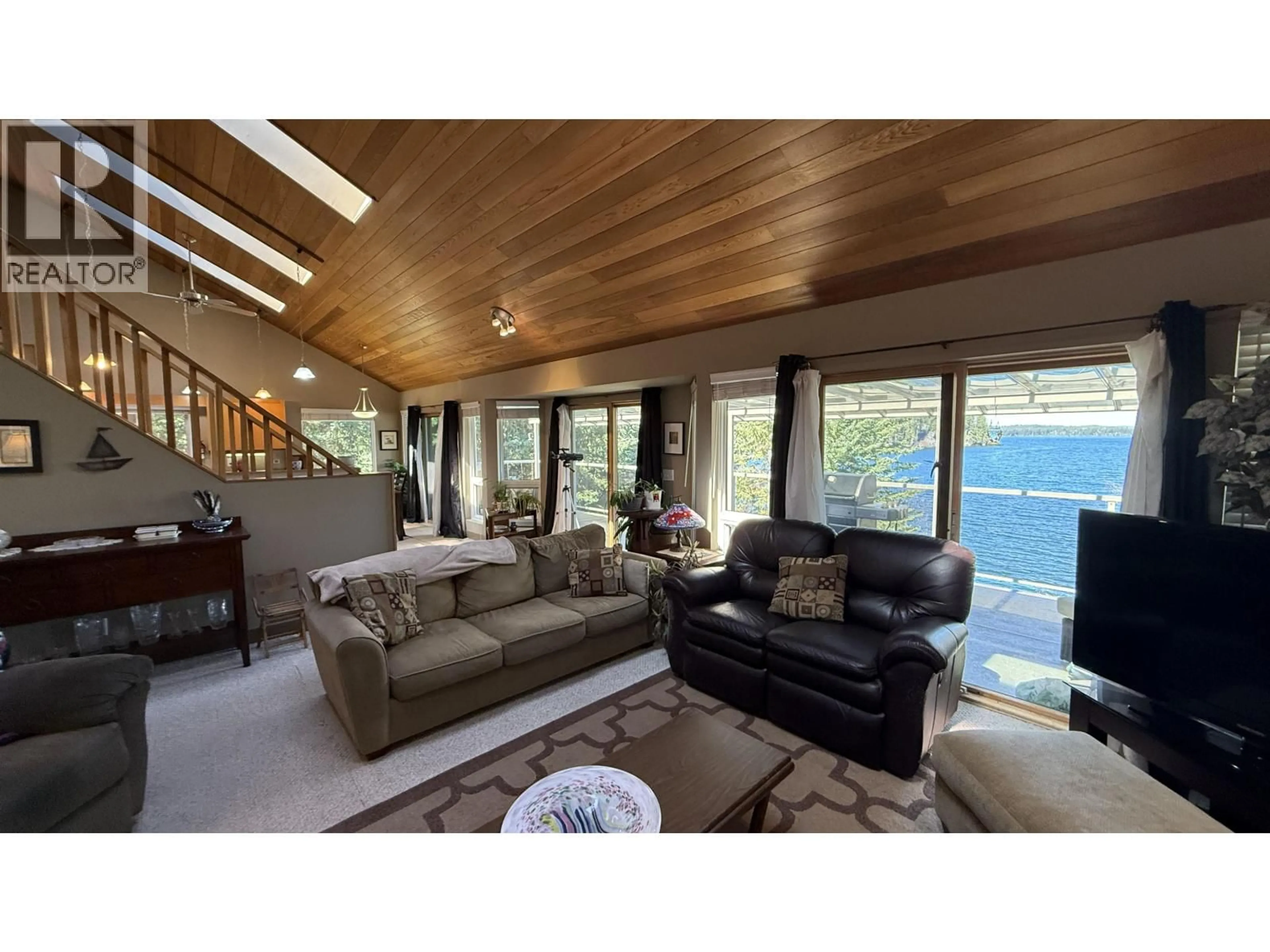Living room with furniture, wood/laminate floor for 8187 COTTONWOOD BAY ROAD, Bridge Lake British Columbia V0K1X2