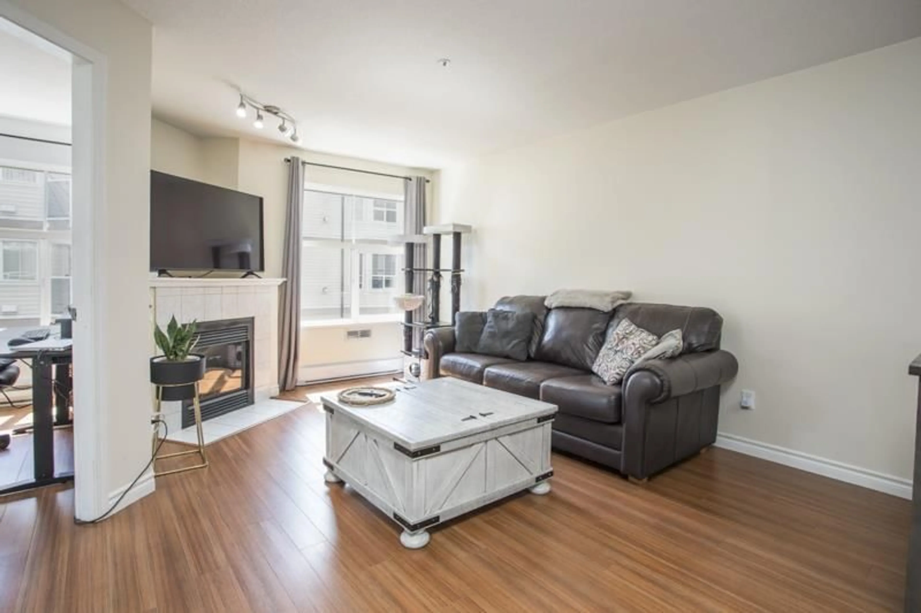 Living room with furniture, wood/laminate floor for 213 - 12739 72 AVENUE, Surrey British Columbia V3W2M7