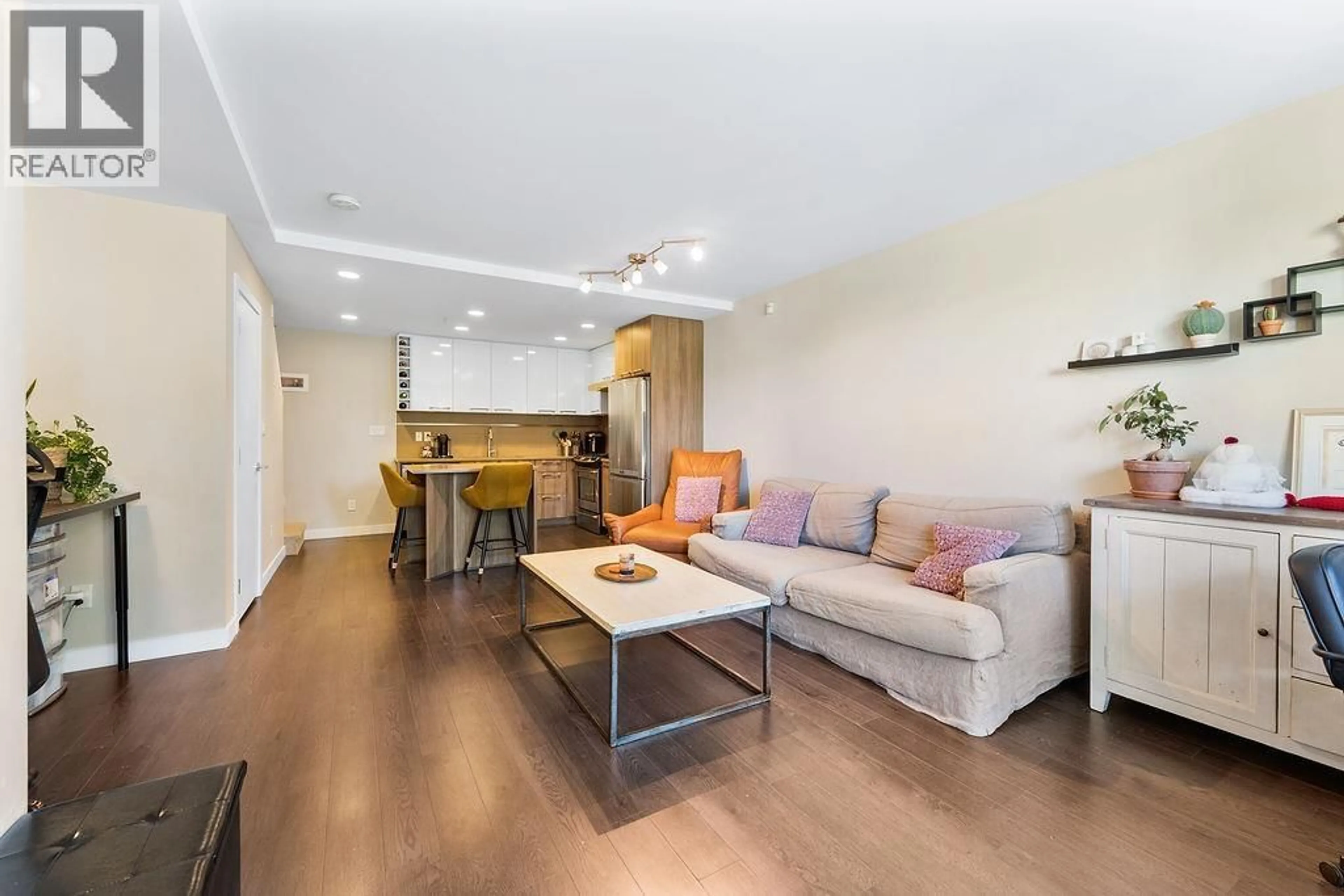 Living room with furniture, wood/laminate floor for 104 - 9350 UNIVERSITY HIGH STREET, Burnaby British Columbia V5A0B6
