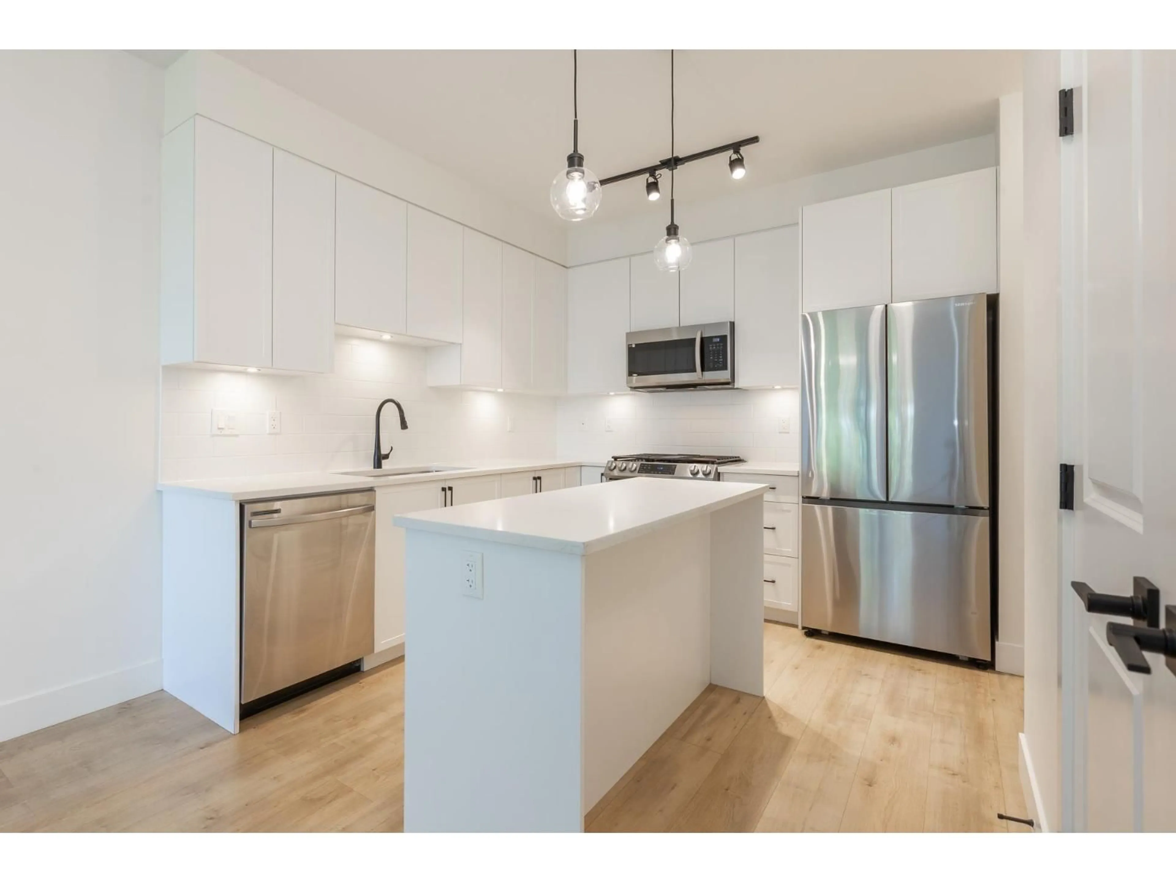 Open concept kitchen, wood/laminate floor for 210 - 19935 75A AVENUE, Langley British Columbia V2R0A2