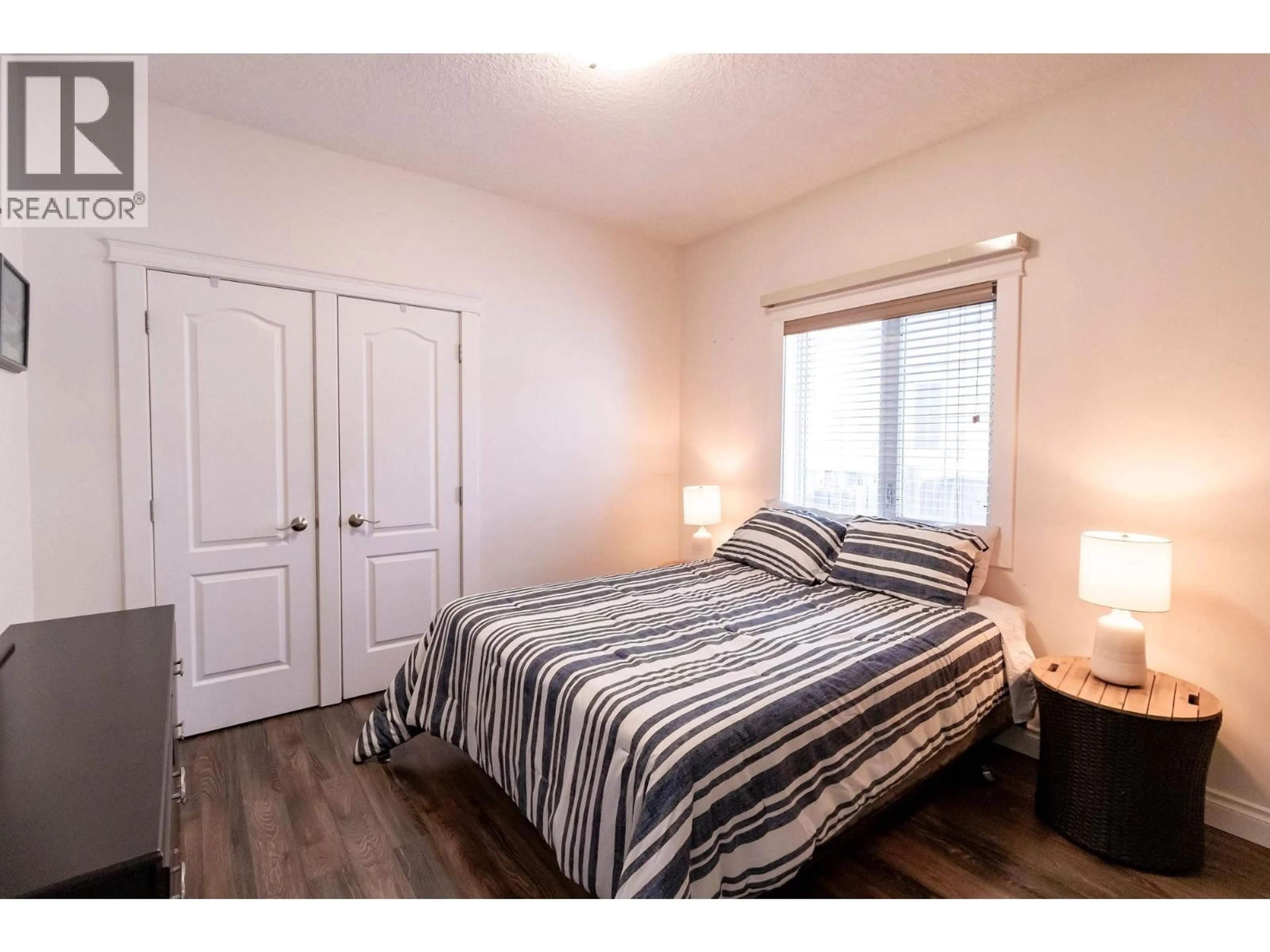 Bedroom with bed, wood/laminate floor for 11007 88A STREET, Fort St. John British Columbia V1J7G2