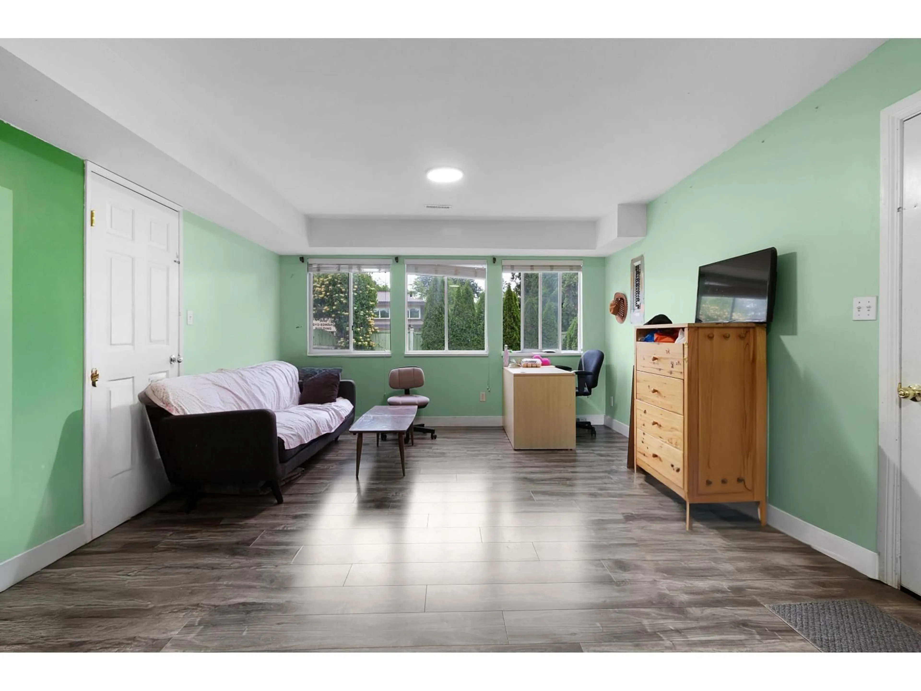 Living room with furniture, wood/laminate floor for 9011 KING GEORGE BOULEVARD, Surrey British Columbia V3V5V7