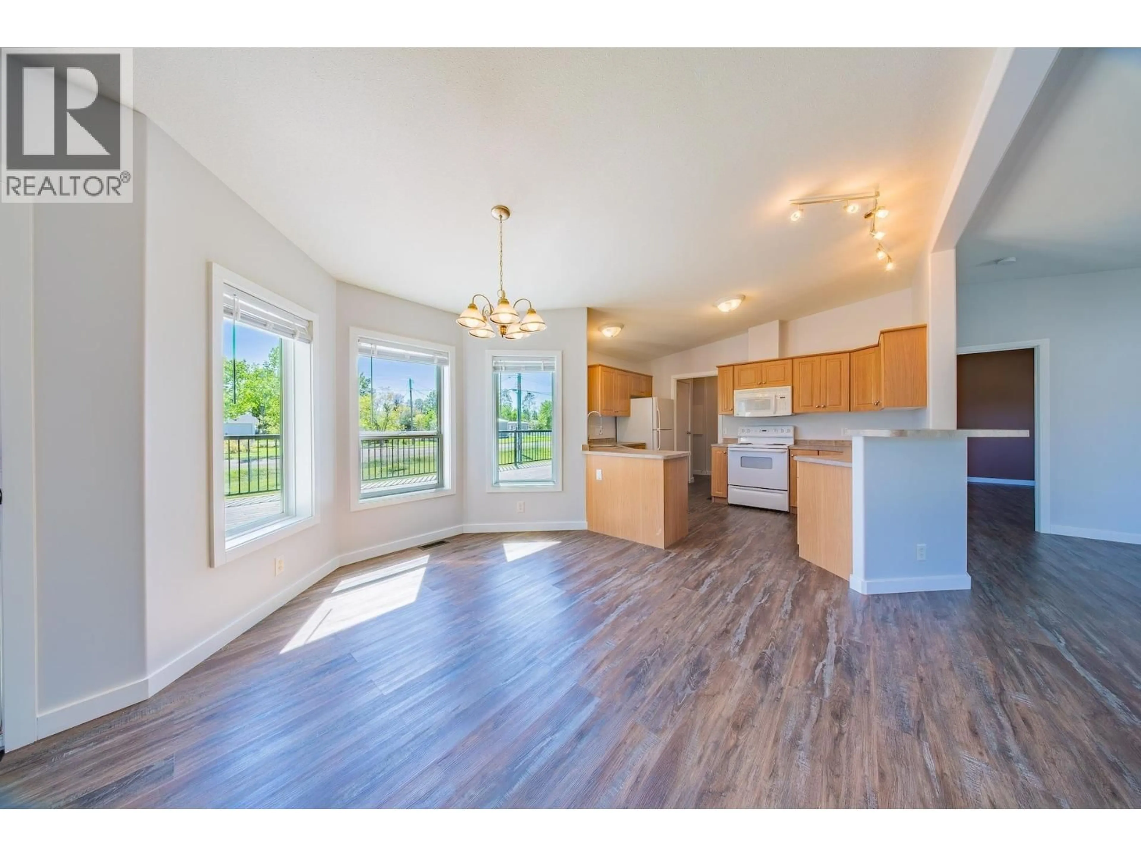 Open concept kitchen, wood/laminate floor for 12222 JUNIPER AVENUE, Fort St. John British Columbia V1J8E5