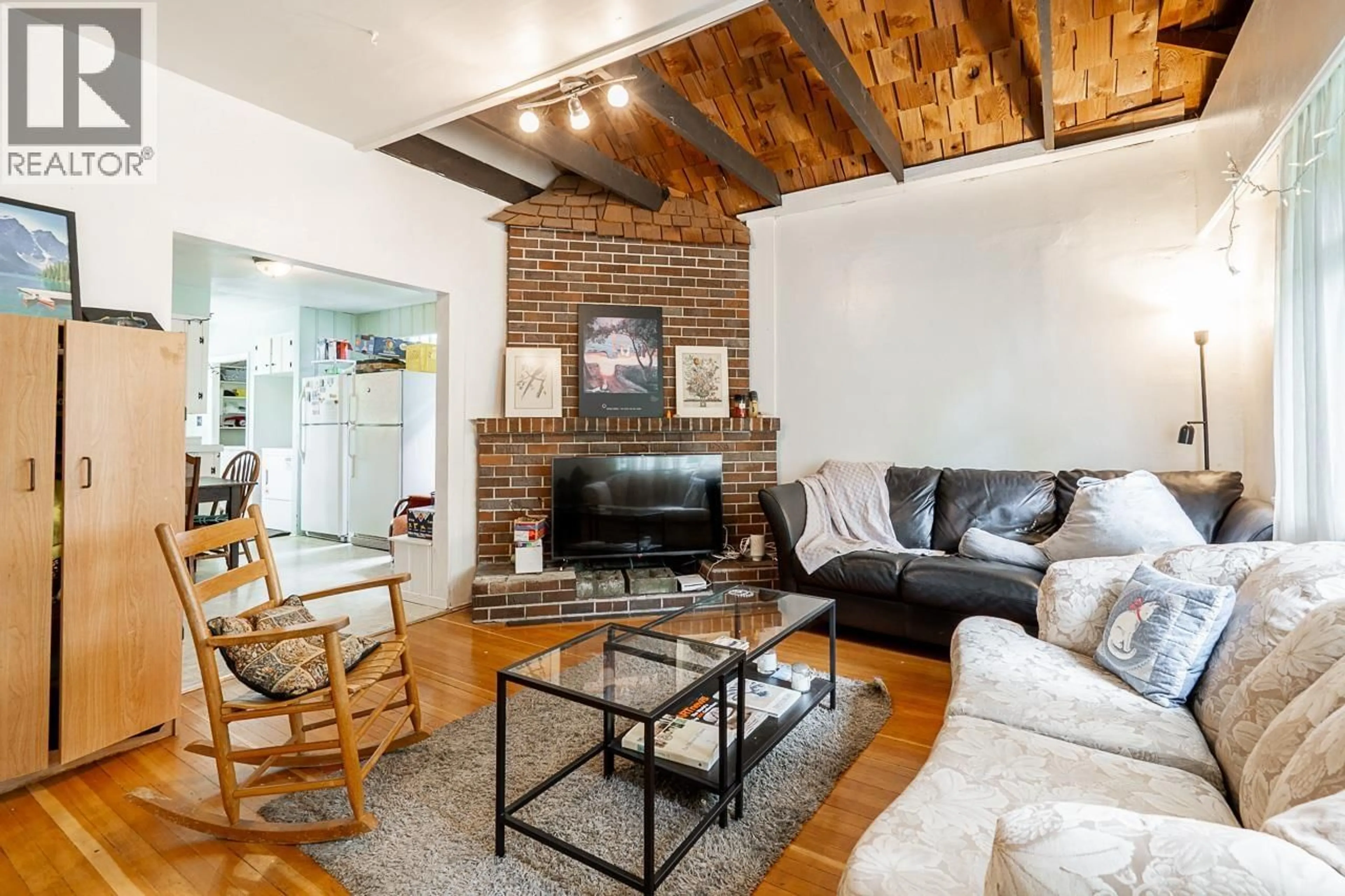 Living room with furniture, wood/laminate floor for 4413 13 AVENUE, Vancouver British Columbia V6R2V2