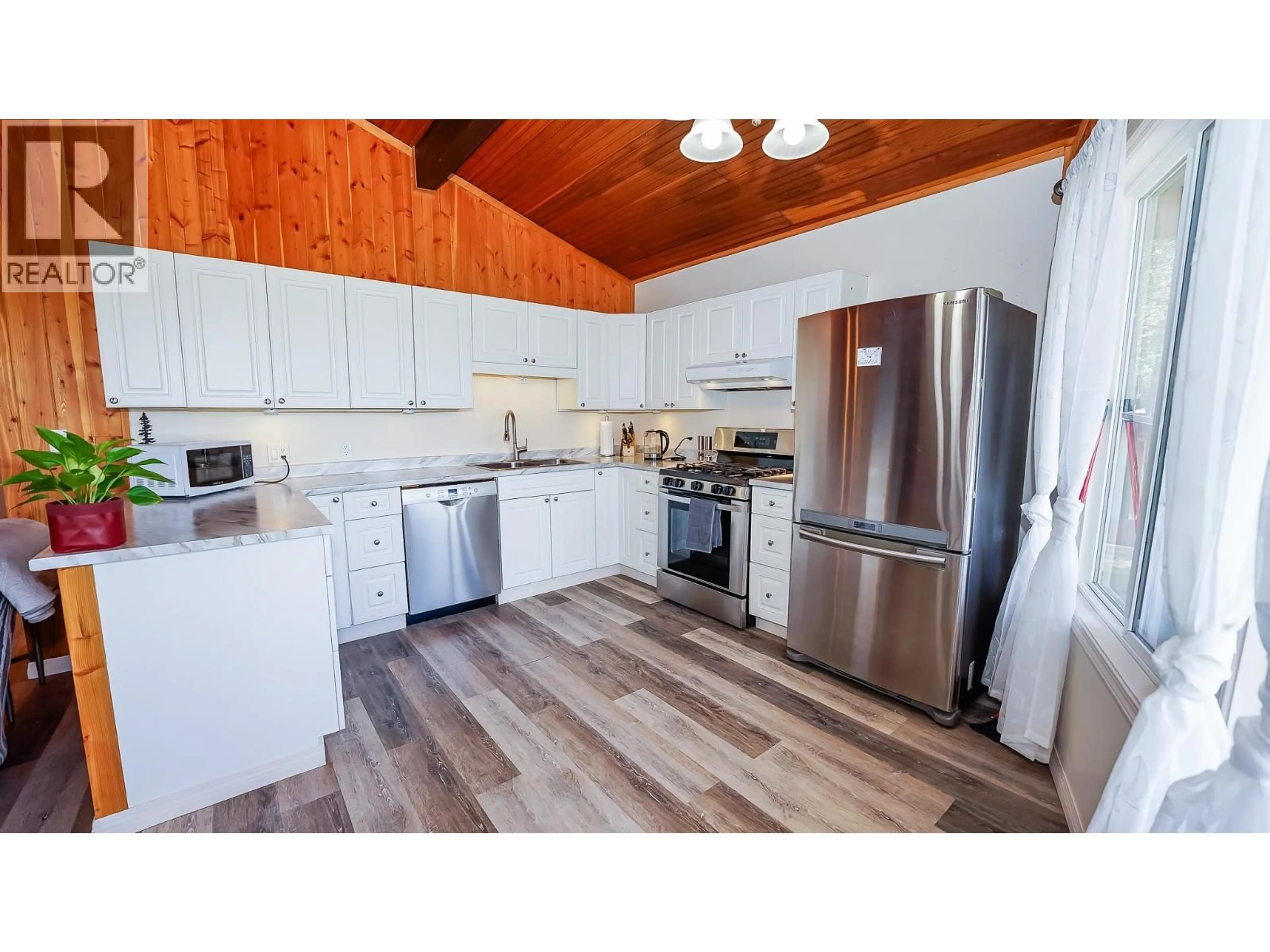 Open concept kitchen, wood/laminate floor for 5080 KINNCUM ROAD, 108 Mile Ranch British Columbia V0K2Z0