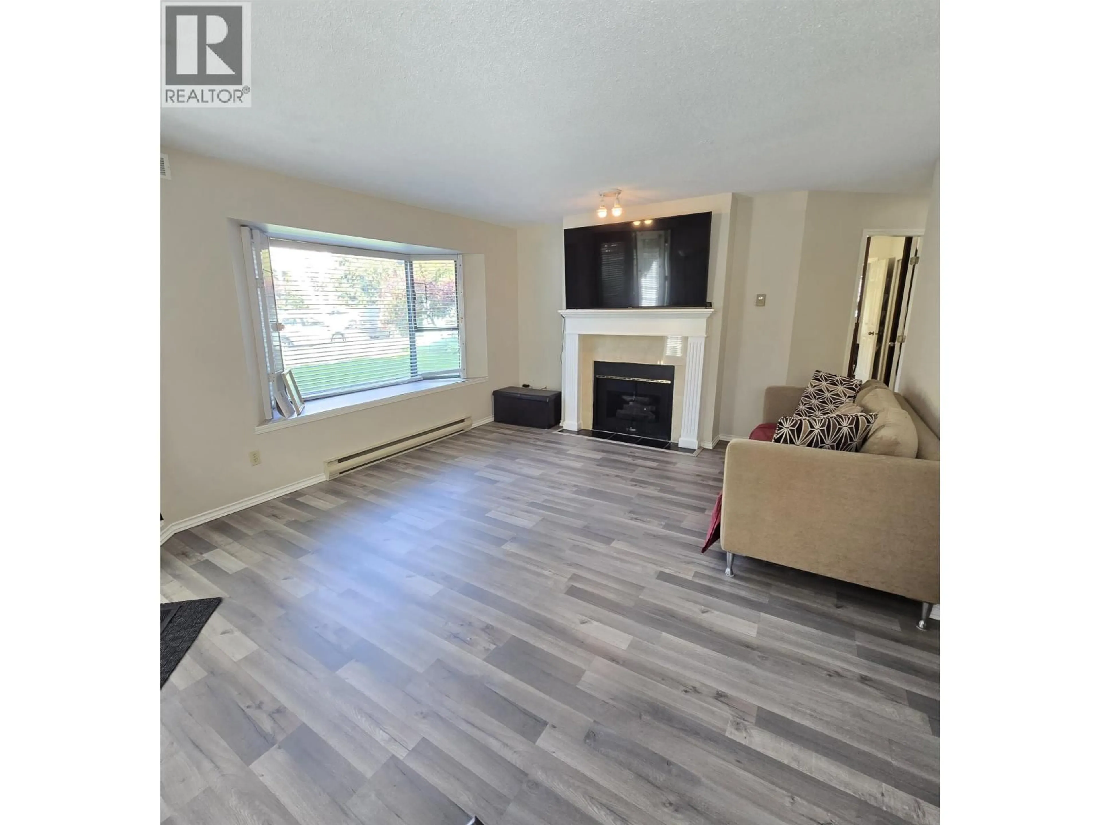 Living room with furniture, wood/laminate floor for 109 - 5250 VICTORY STREET, Burnaby British Columbia V5J5H2