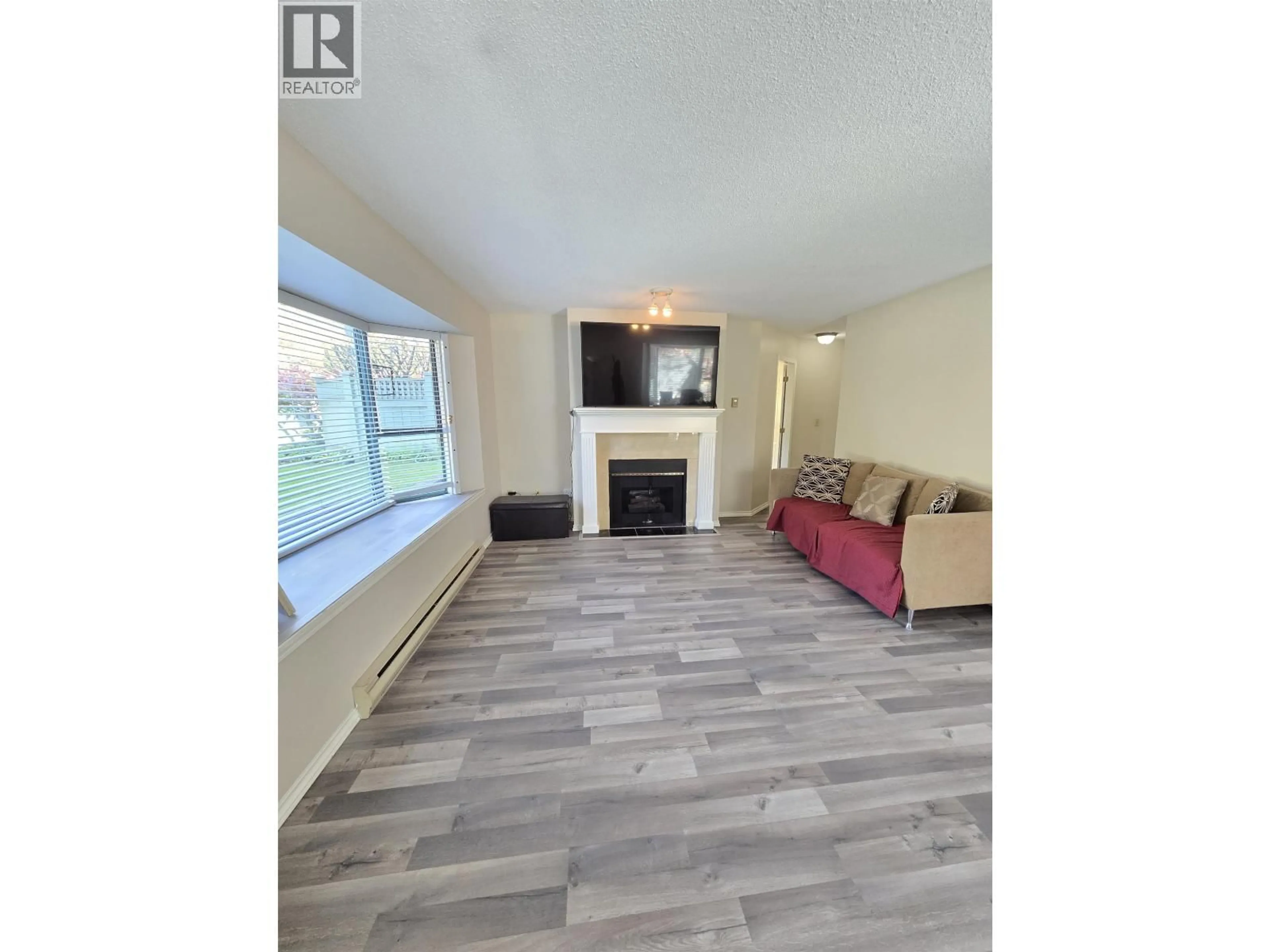 Living room with furniture, wood/laminate floor for 109 - 5250 VICTORY STREET, Burnaby British Columbia V5J5H2