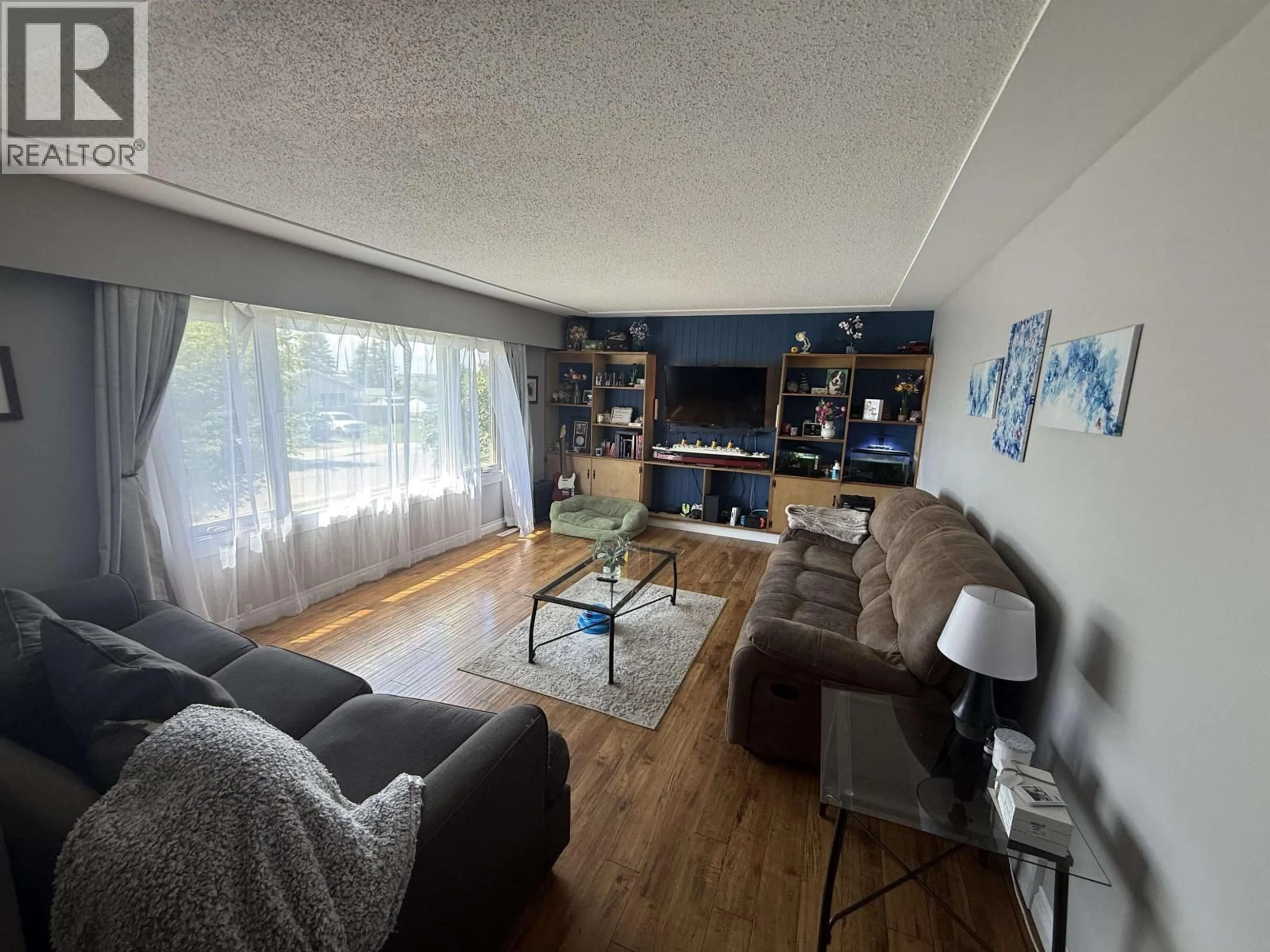Living room with furniture, wood/laminate floor for 10712 102 AVENUE, Fort St. John British Columbia V1J2E8