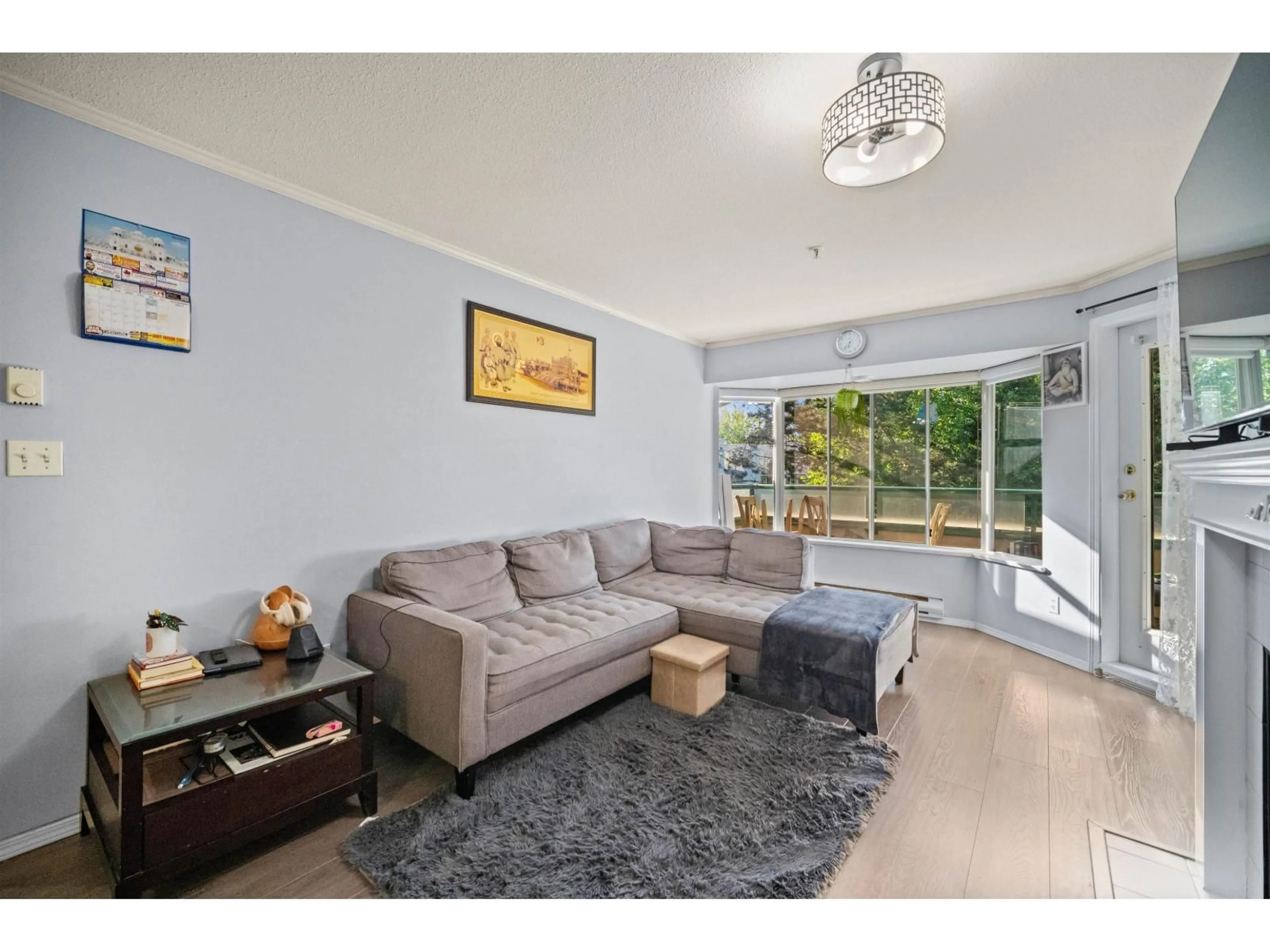 Living room with furniture, wood/laminate floor for 207 - 2962 TRETHEWEY STREET, Abbotsford British Columbia V2T4M3