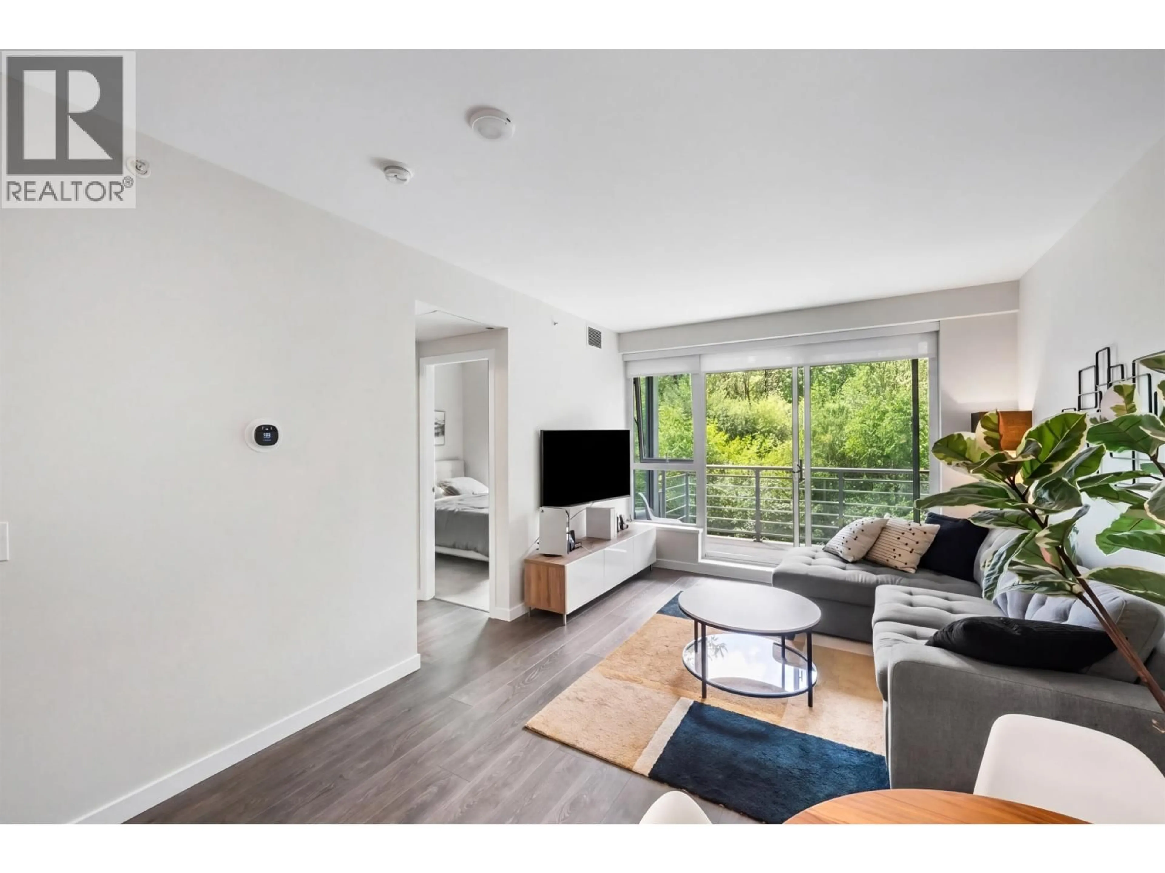 Living room with furniture, wood/laminate floor for 405 - 308 MORRISSEY ROAD, Port Moody British Columbia V3H0M2