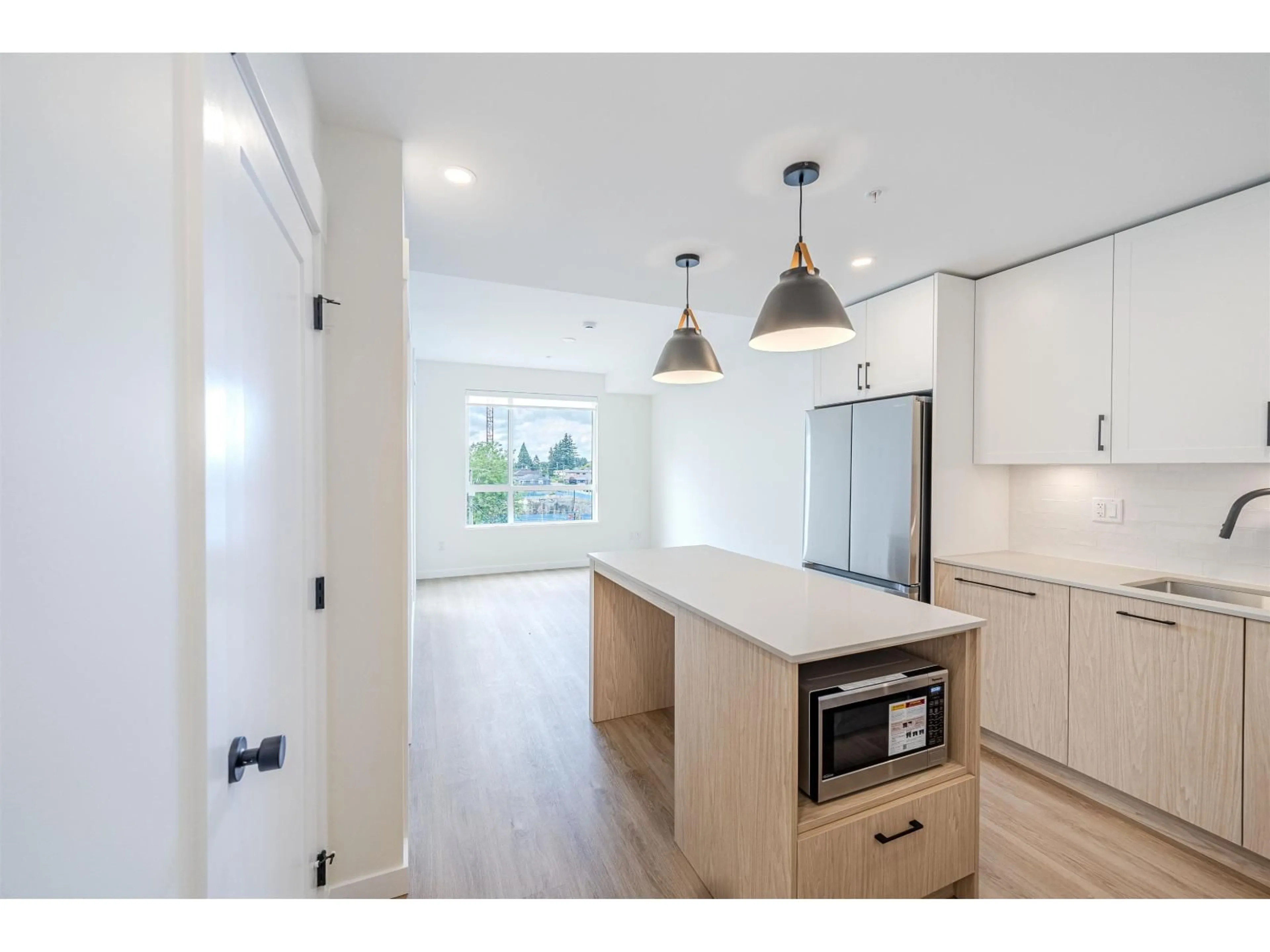 Open concept kitchen, wood/laminate floor for 315 - 27218 ALDERGROVE TOWN CENTRE DRIVE, Abbotsford British Columbia V4W3N7